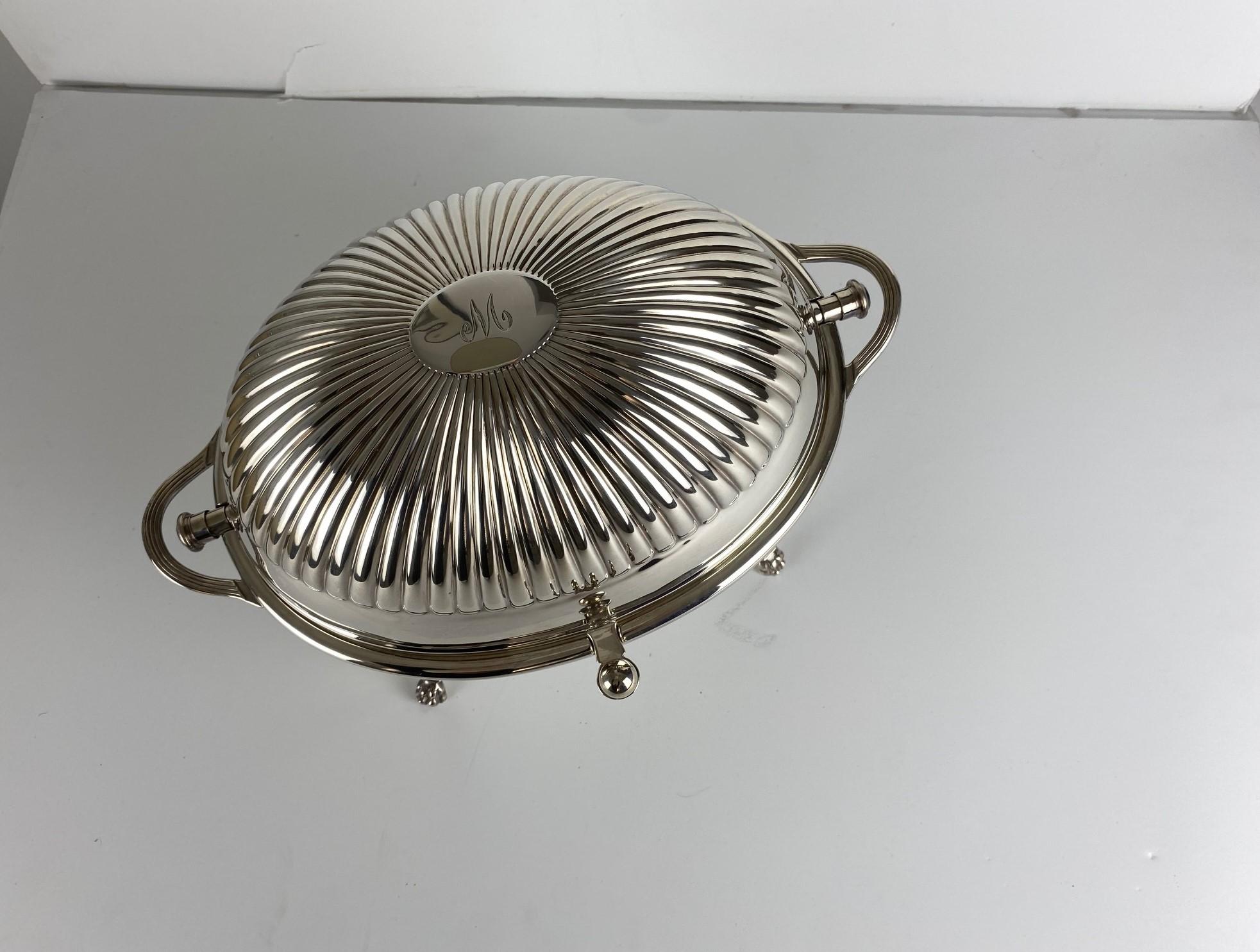 This is an antique roll-over serving dish. An English, silver plated dome top tureen or server, engraved 
