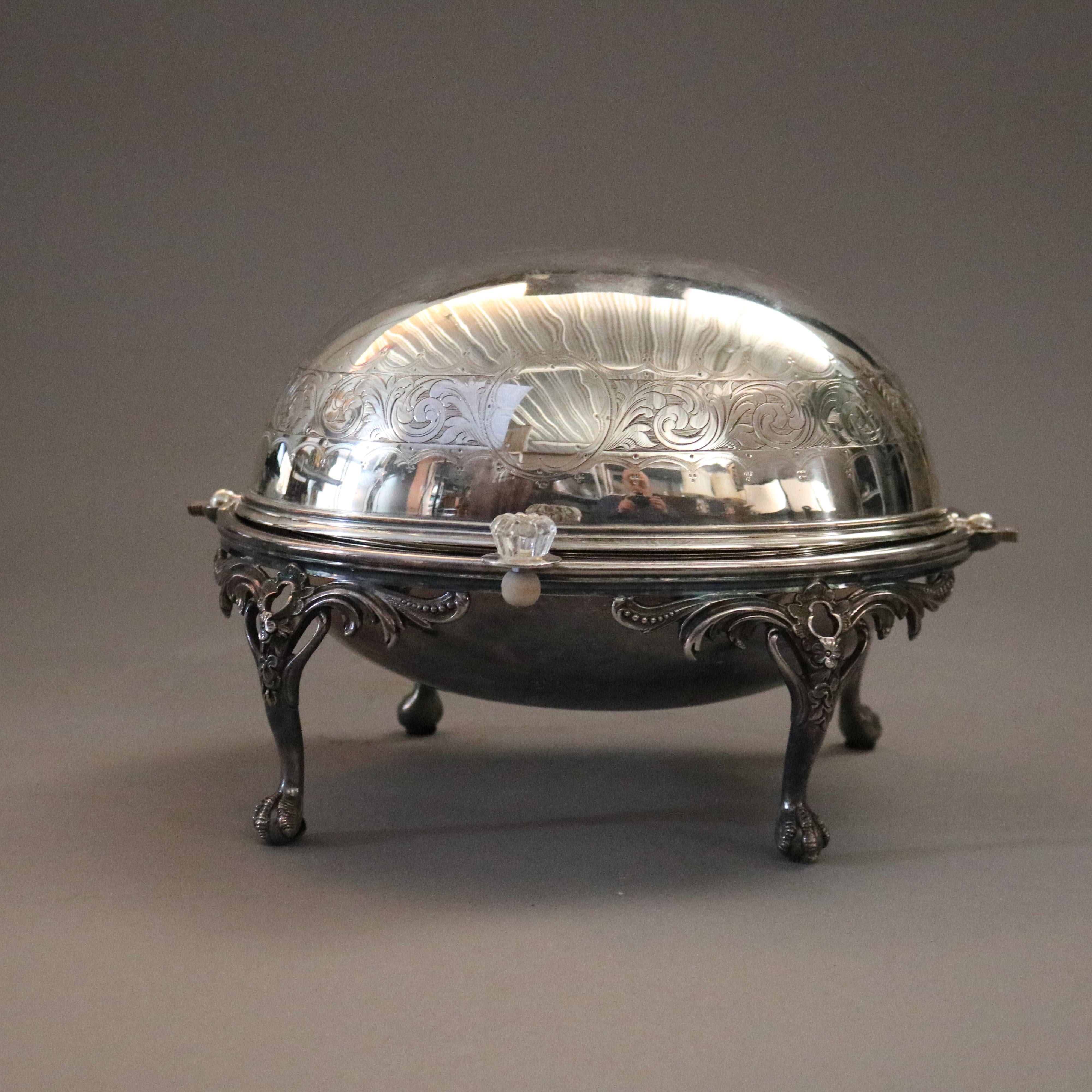 An English silver plate serving dish offers swivel dome top having engraved acanthus band and raised on cabriole legs with foliate capitals and terminating in claw and ball feet, 20th century.

Measures - 8''H X 12.5''W X 9.75''D.