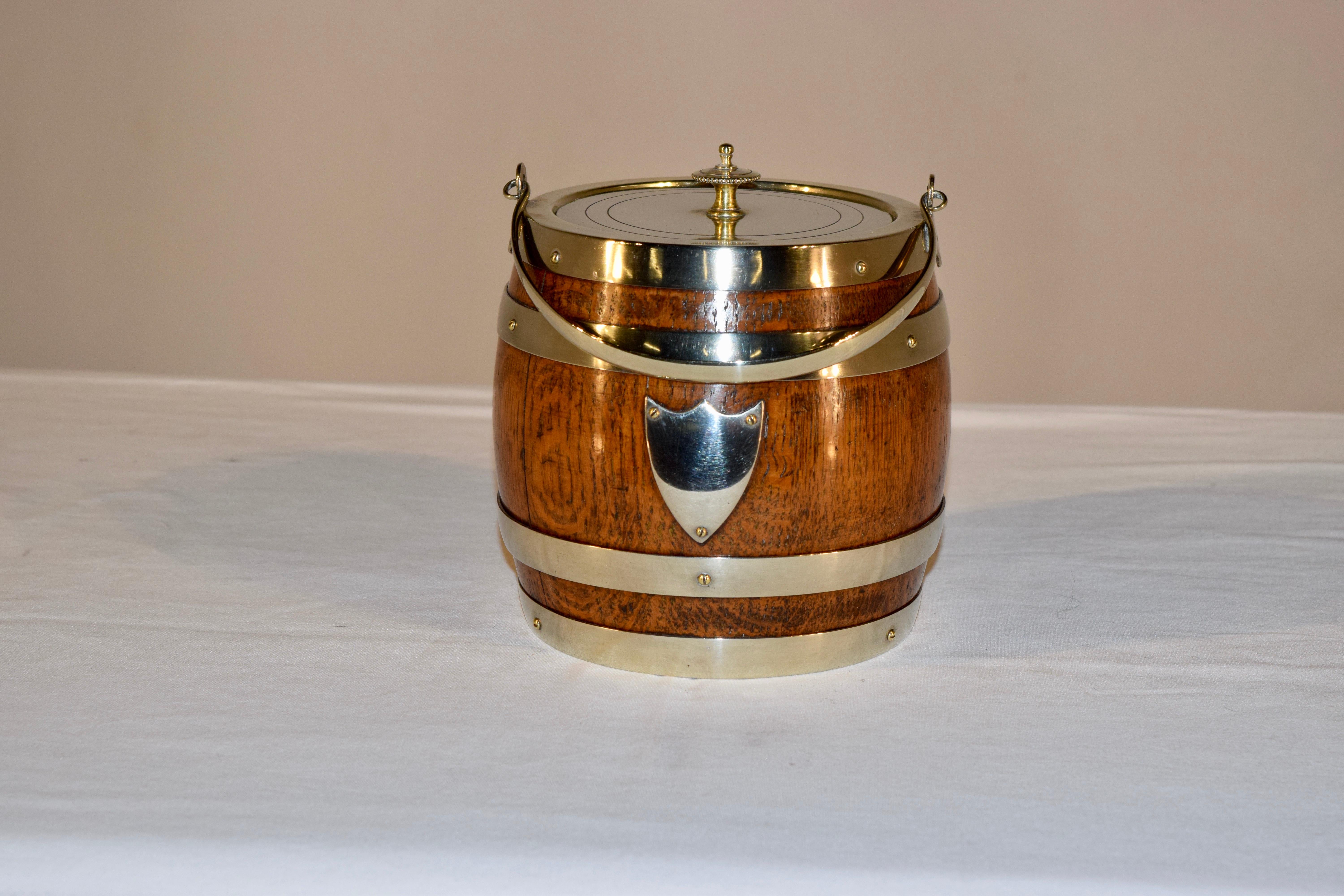 English oak biscuit barrel with silver plated lid and banding. It retains the original porcelain liner inside. The lid is stamped Daniel & Arter in Birmingham.
  