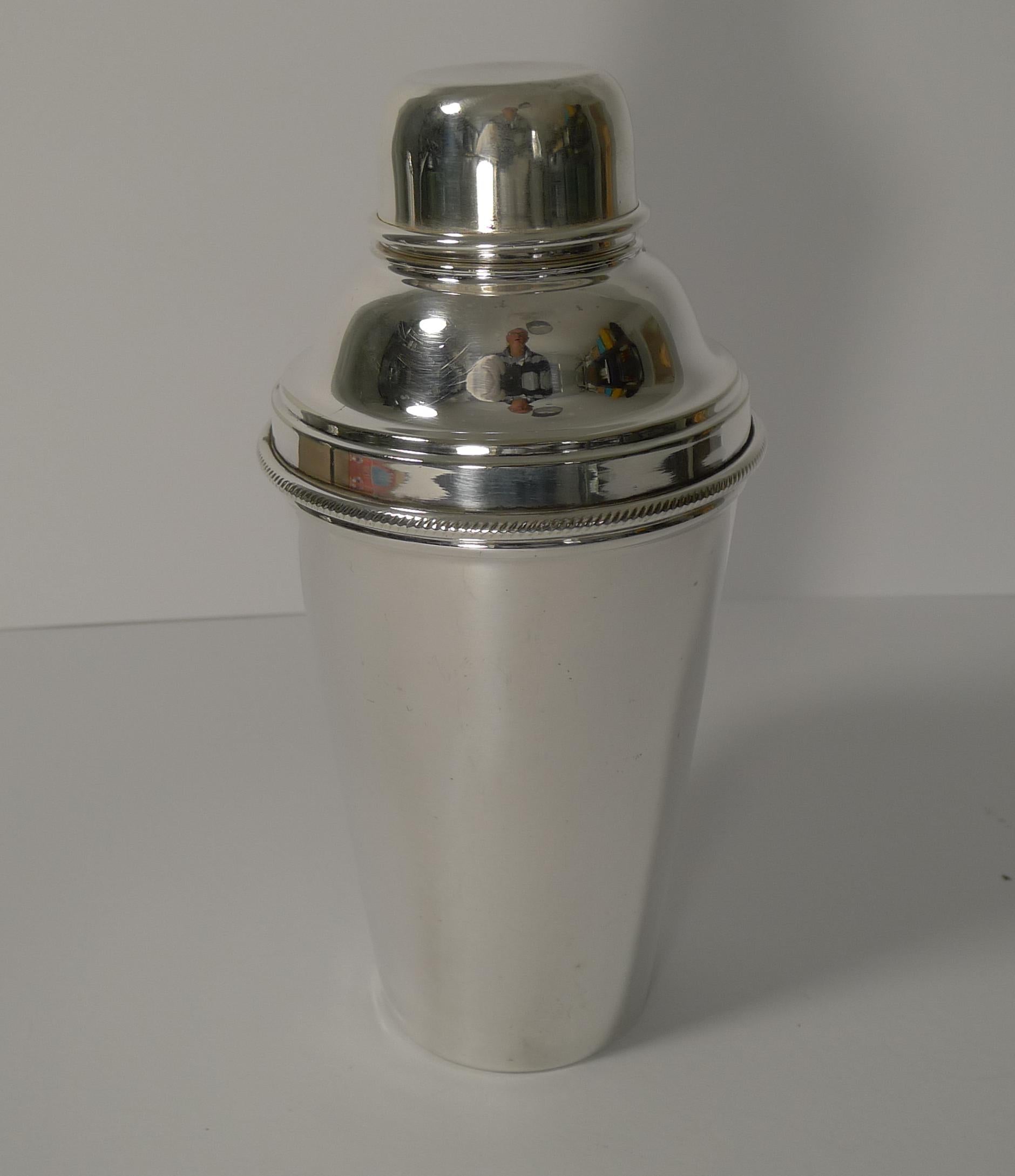 Always highly sought-after and hard to find, this vintage Art Deco cocktail shaker has an integral lemon squeezer or reamer built into the top section of the shaker.

Made from English silver plate, it is fully marked on the underside for the