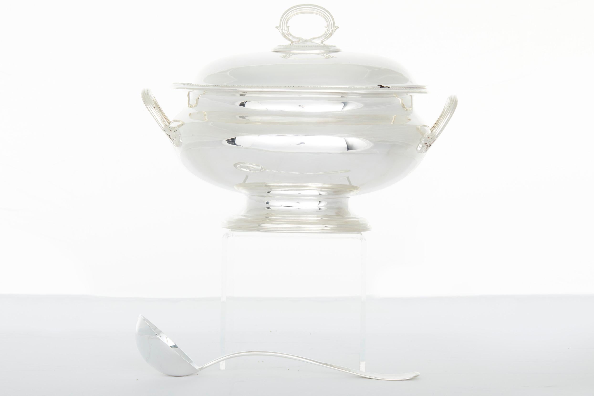 English silver plated tableware covered soup tureen / serving piece with two side handles and exterior top finial design details. The tureen is in great condition. Minor wear consistent with age / use. Maker's mark undersigned. The tureen stands