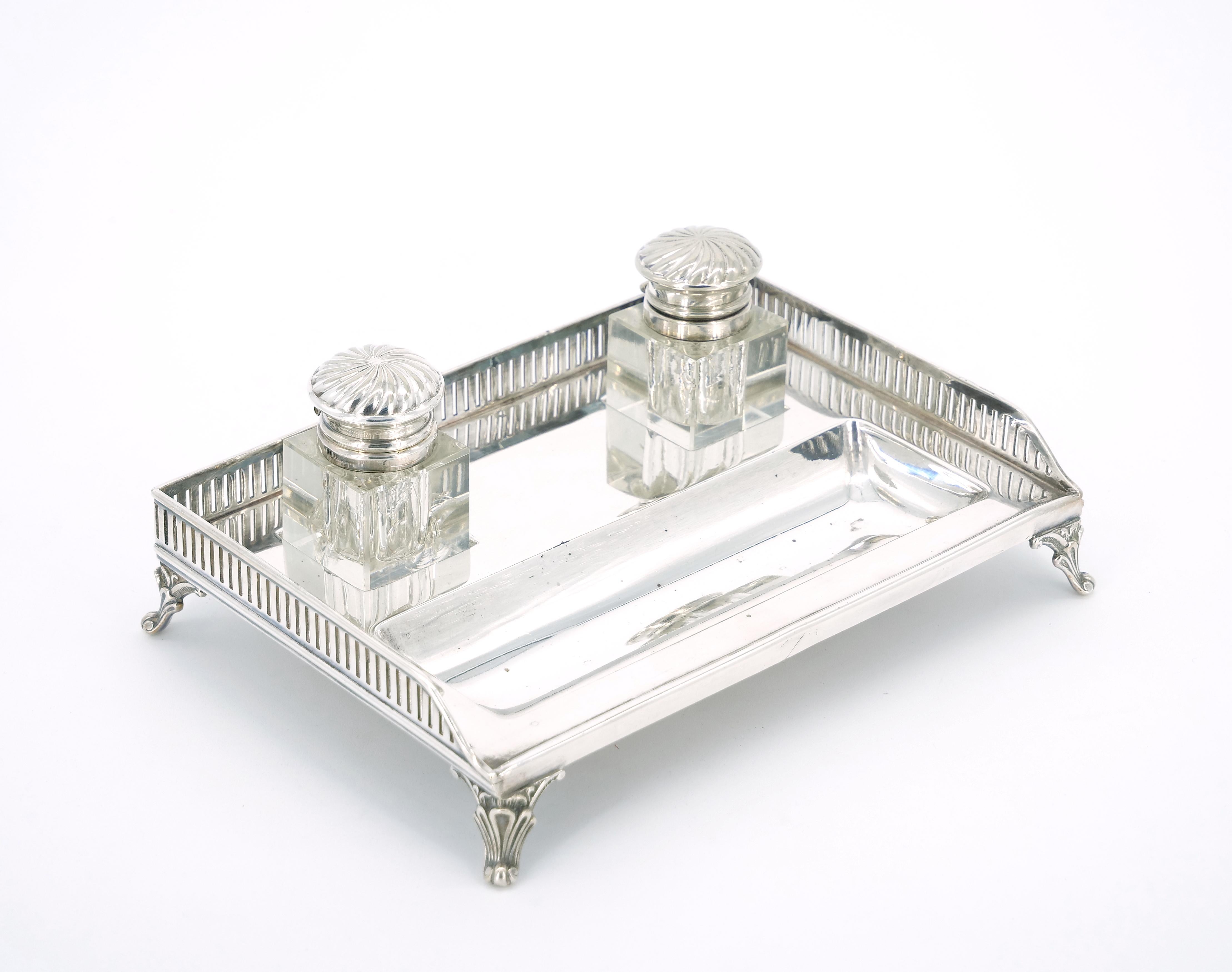 Introduce a touch of refinement to your desk or workspace with this English Silver Plated Gallery Top Rectangle Footed Holding Base, featuring an exquisite cut glass inkwell. The silver plate holding base boasts a gallery top tray, creating a