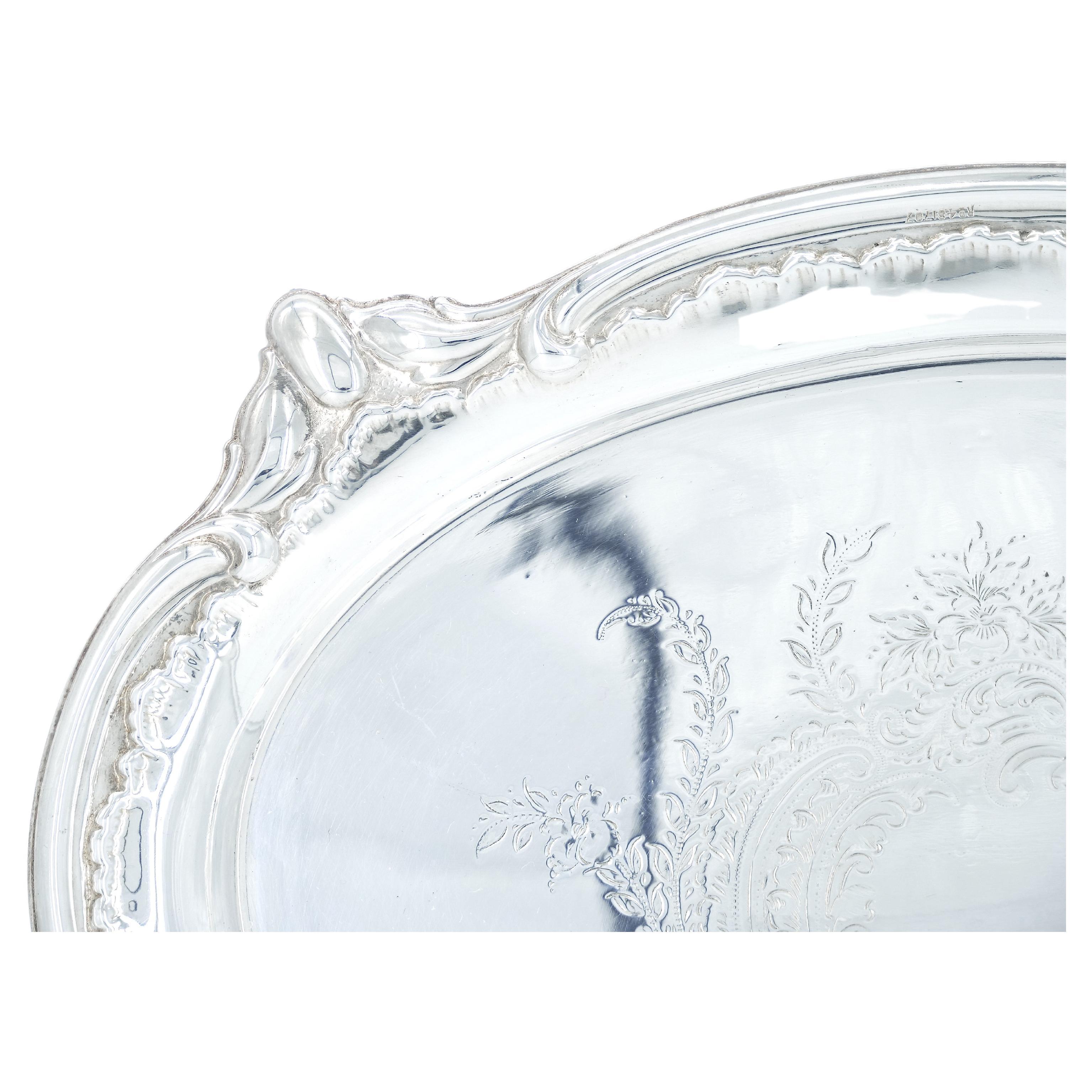 Elevate your hosting experience with our exquisite English Sheffield silver plated serving tray. This captivating piece not only showcase the timeless beauty of silver, but also features an intricately engraved design on its interior, adding a touch