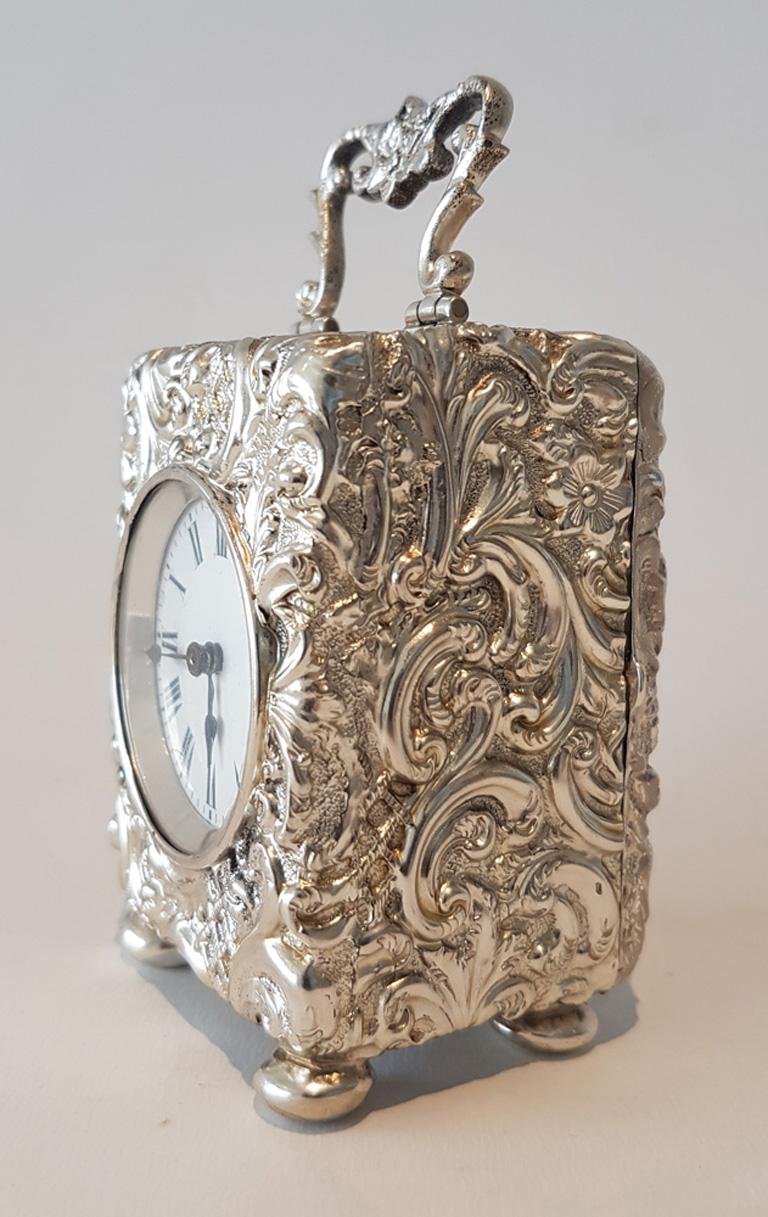 A fine English silver rococo style miniature carriage clock by Henry Matthews of Birmingham. The fine white enamel dial with roman numerals and blued steel spade hands. The movement is a good 8 day with platform escapement, stamped with the lion.