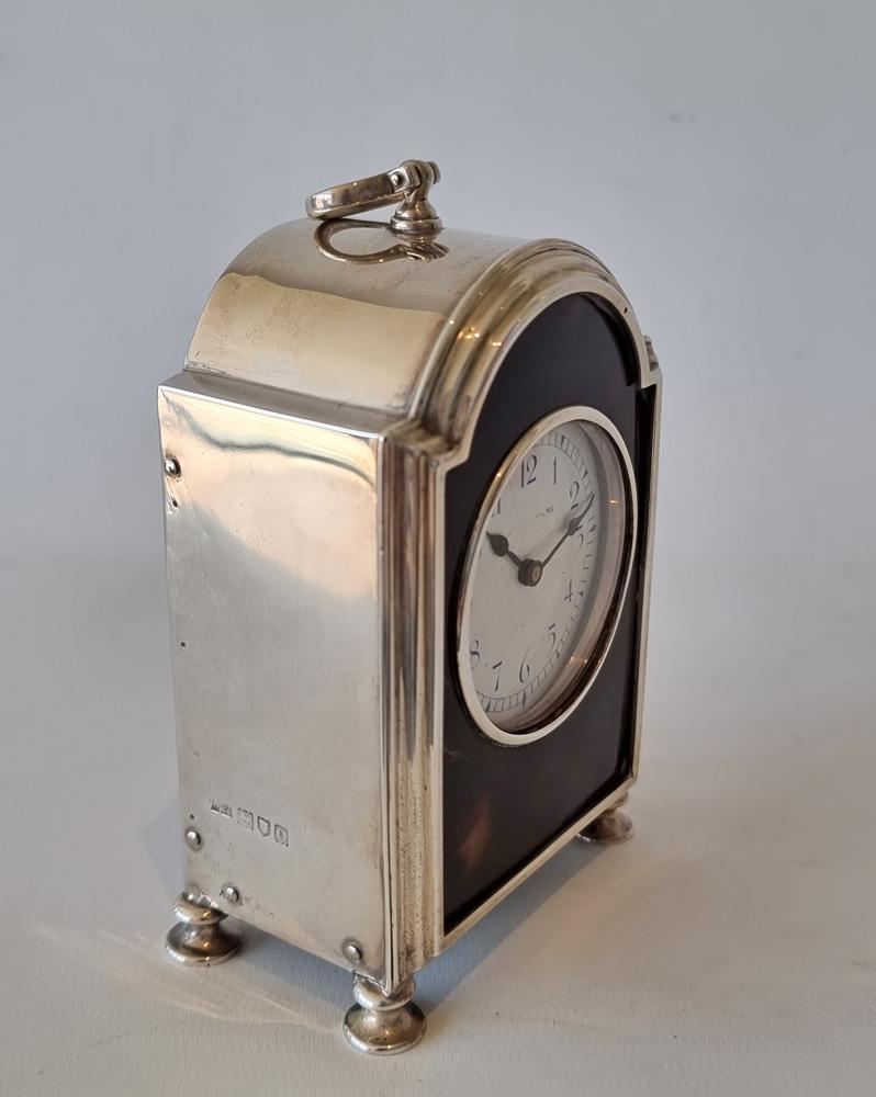A good English Edwardian silver and tortoiseshell hump backed carriage clock. With a French 8 day movement with lever escapement. Porcelain dial. Hallmarked for 1912 and with London Sterling silver standard marks.