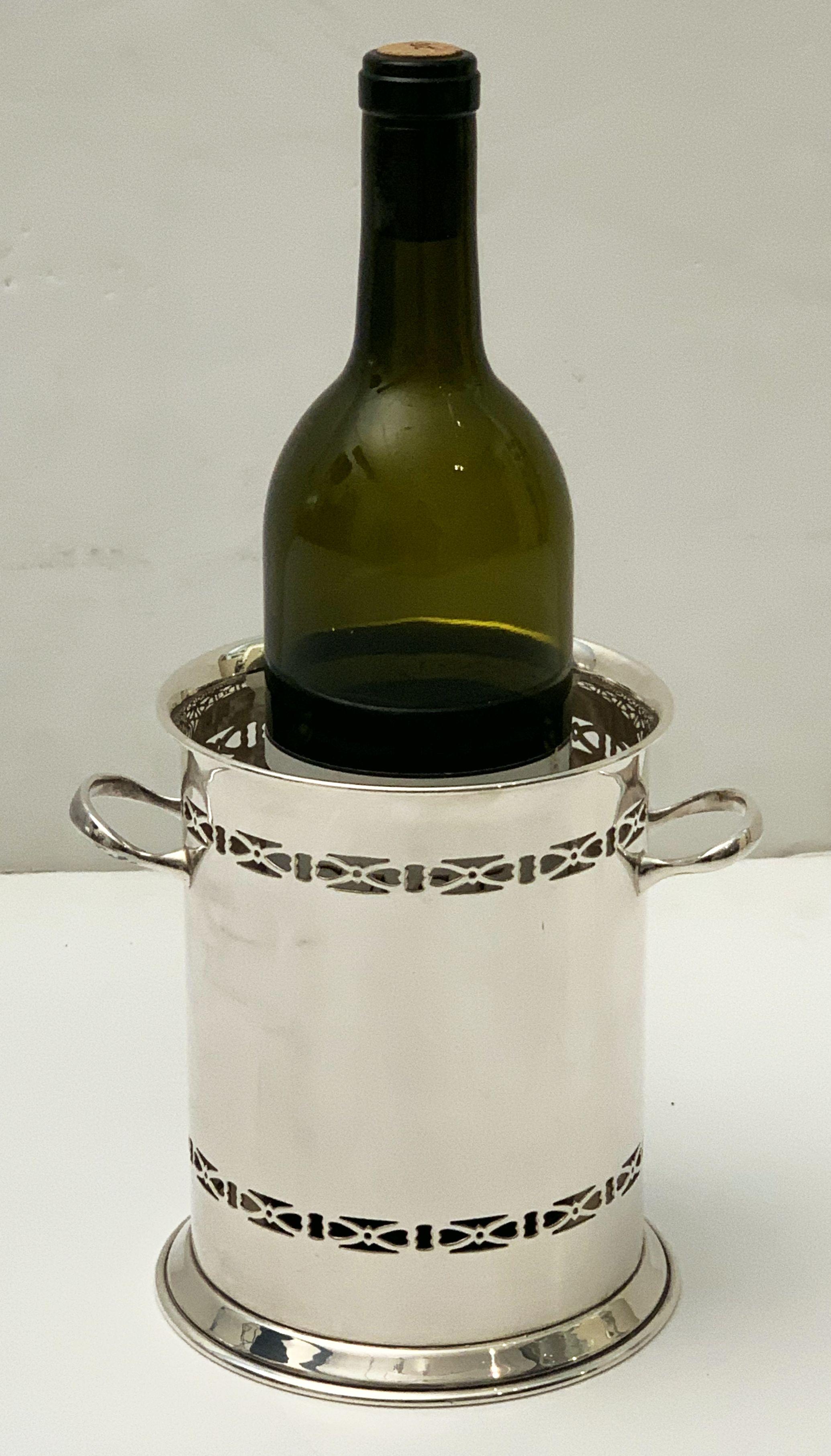 A handsome English wine bottle display holder or coaster of fine plate silver, featuring a pierced design around the circumference and opposing handles.

Designed to add a fine level of elegance to the presentation of wine at the table.