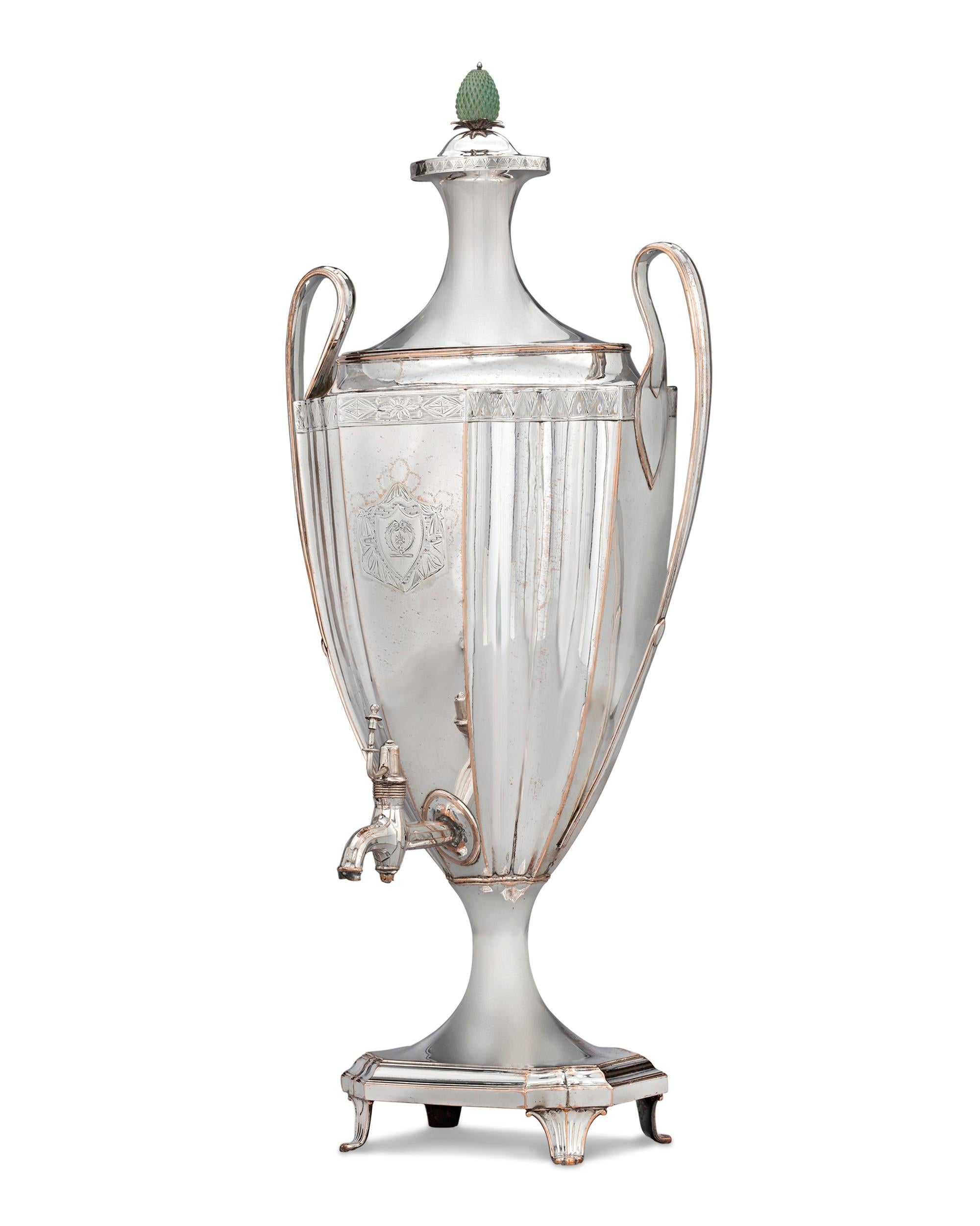 This exceptional English silverplate tea urn is the perfect accessory for serving tea, coffee or hot water. The piece exhibits all the hallmarks of the Neoclassical style, from the acorn finial to the stunning fluting and engraved crest on the