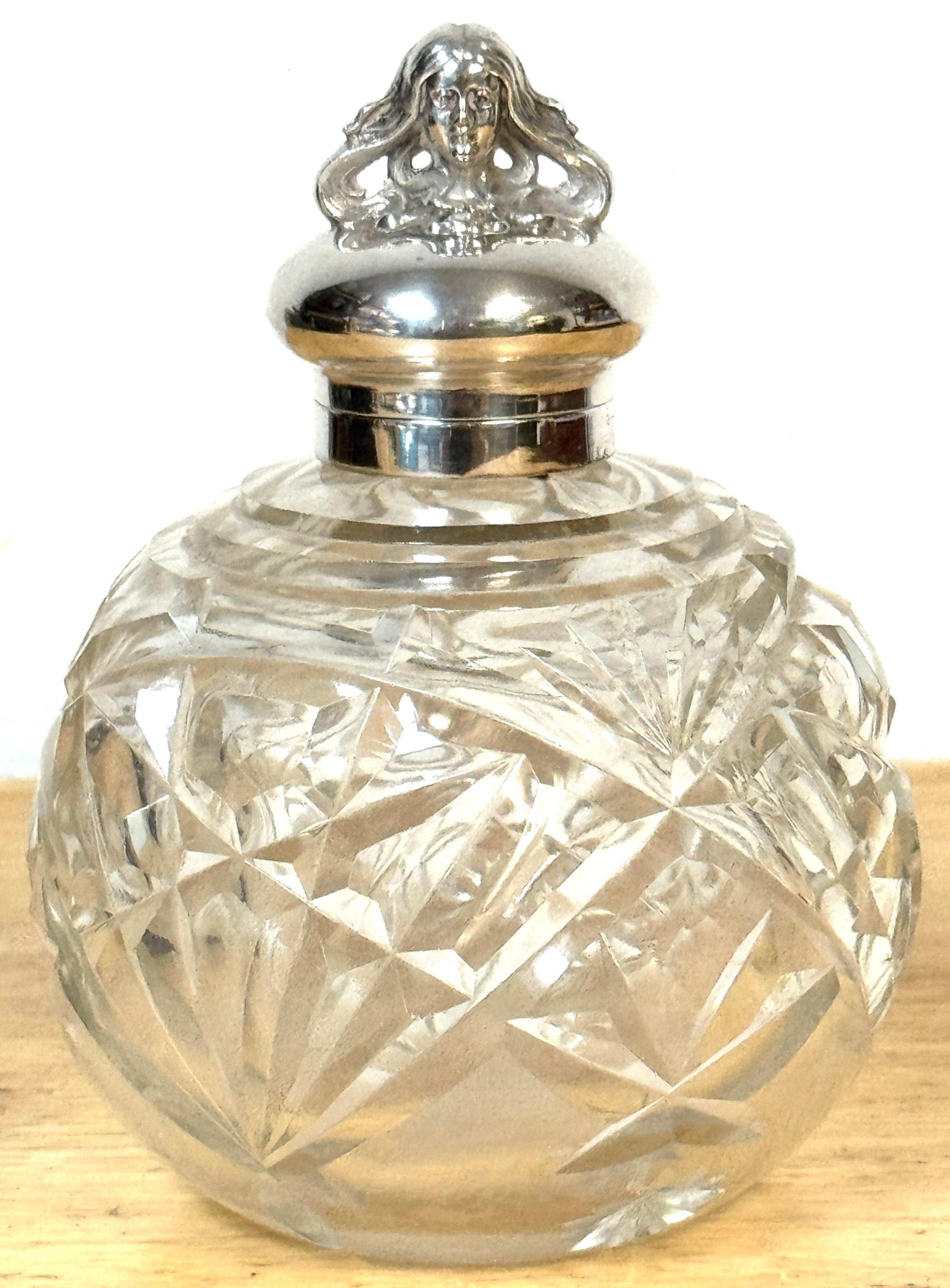 Walker & Hall Attributed Art Nouveau Silverplate and Cut Glass Perfume Bottle, England, circa 1905

An exceptional English Art Nouveau perfume bottle, circa 1905, attributed to Walker & Hall. The hinged silver-plated lid is surmounted by a figural