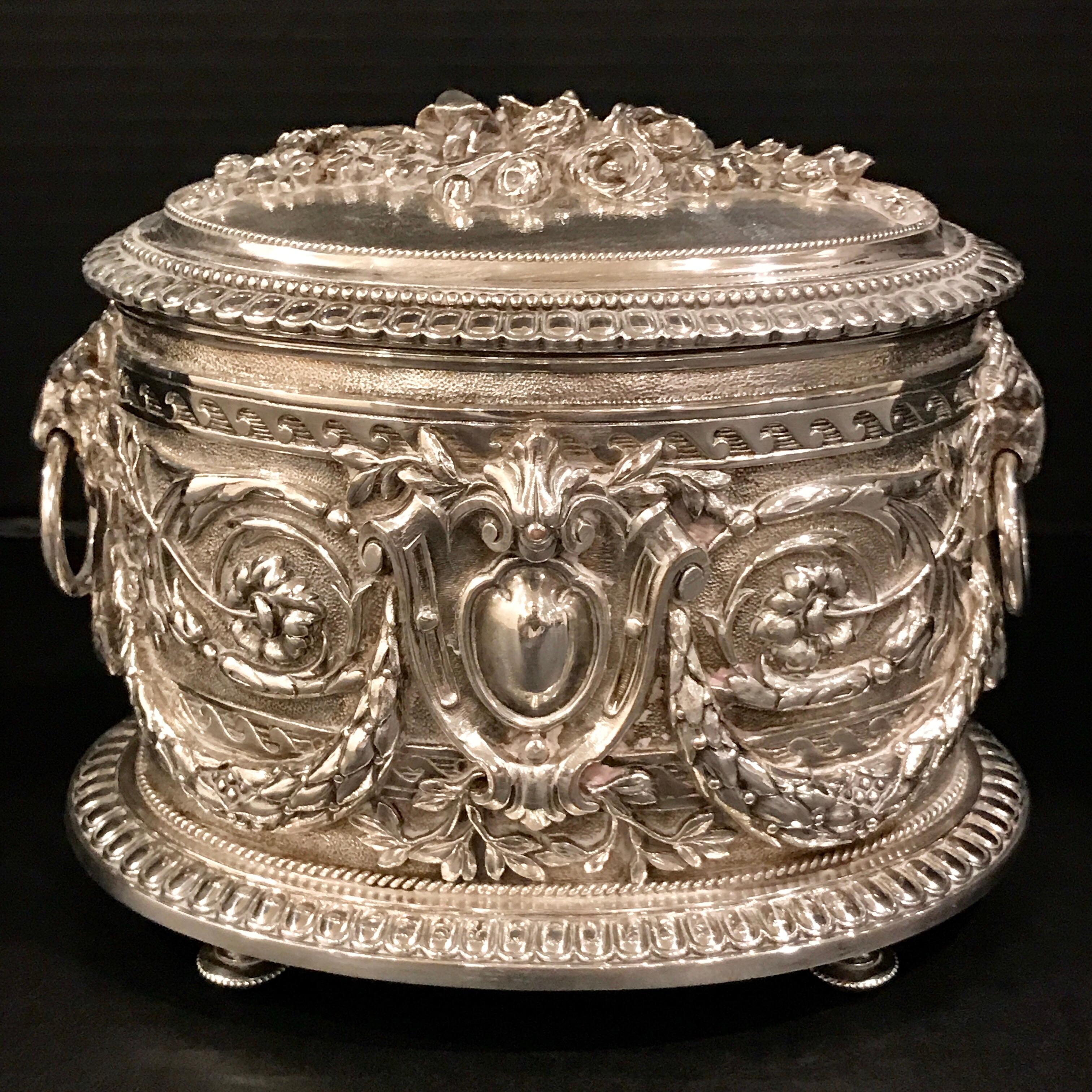 A spectacular repoused oval table box with lion handles, maker's marks for Hukin and Heath, Birmingham.
Measures: 4” interior depth x 5