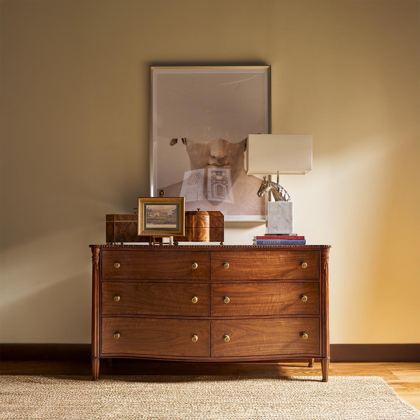 L'elegante fronte a serpentina crea una silhouette fluida, completata da sei spaziosi cassetti a fasce incrociate che mettono in mostra la maestria e l'equilibrio del legno.

Realizzato in legno massiccio con una calda finitura noce, questo comò è