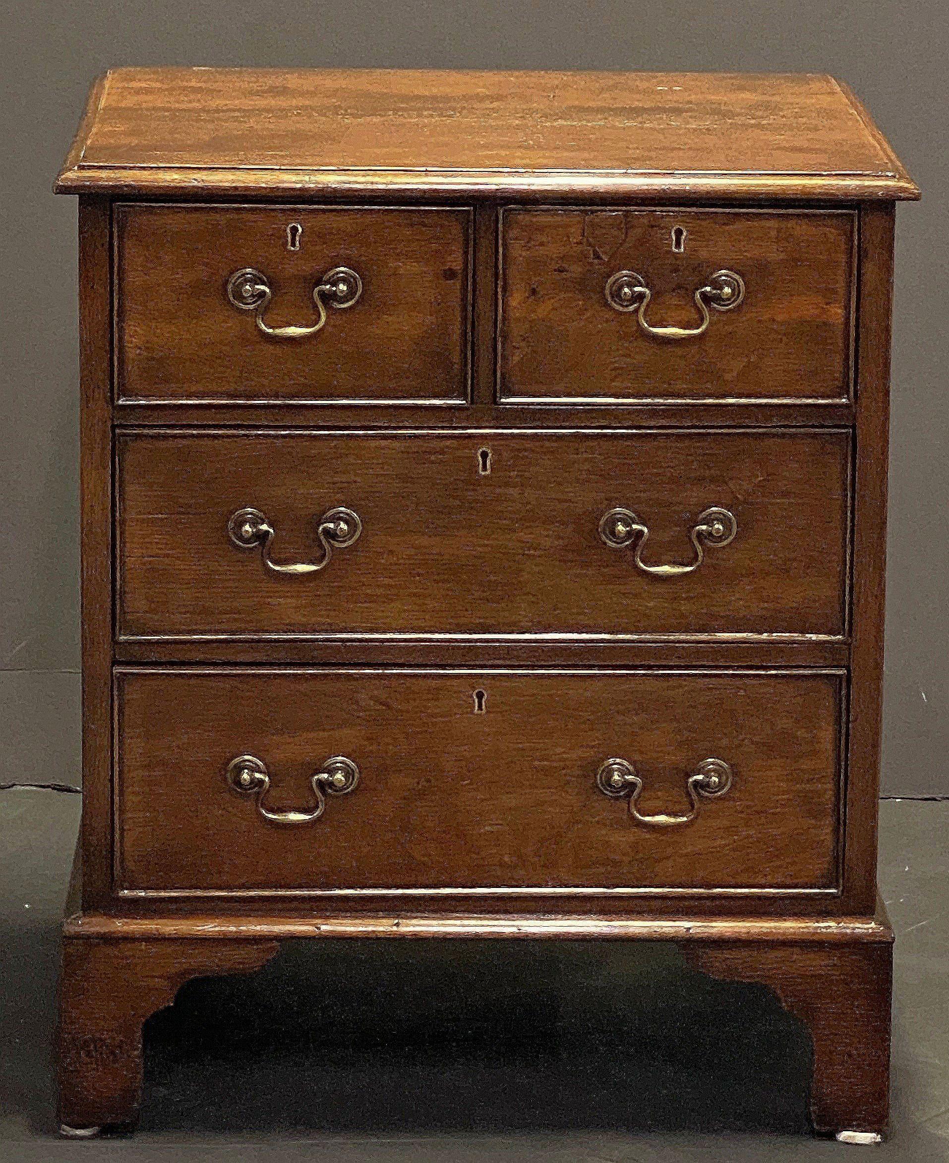 Un raffinato cassettone inglese in rovere patinato del XIX secolo, caratterizzato da un piano modanato su un fregio di due cassetti corti perlinati e due cassetti lunghi perlinati, ogni cassetto con tiretti in ottone e rosetta in ottone, e montato