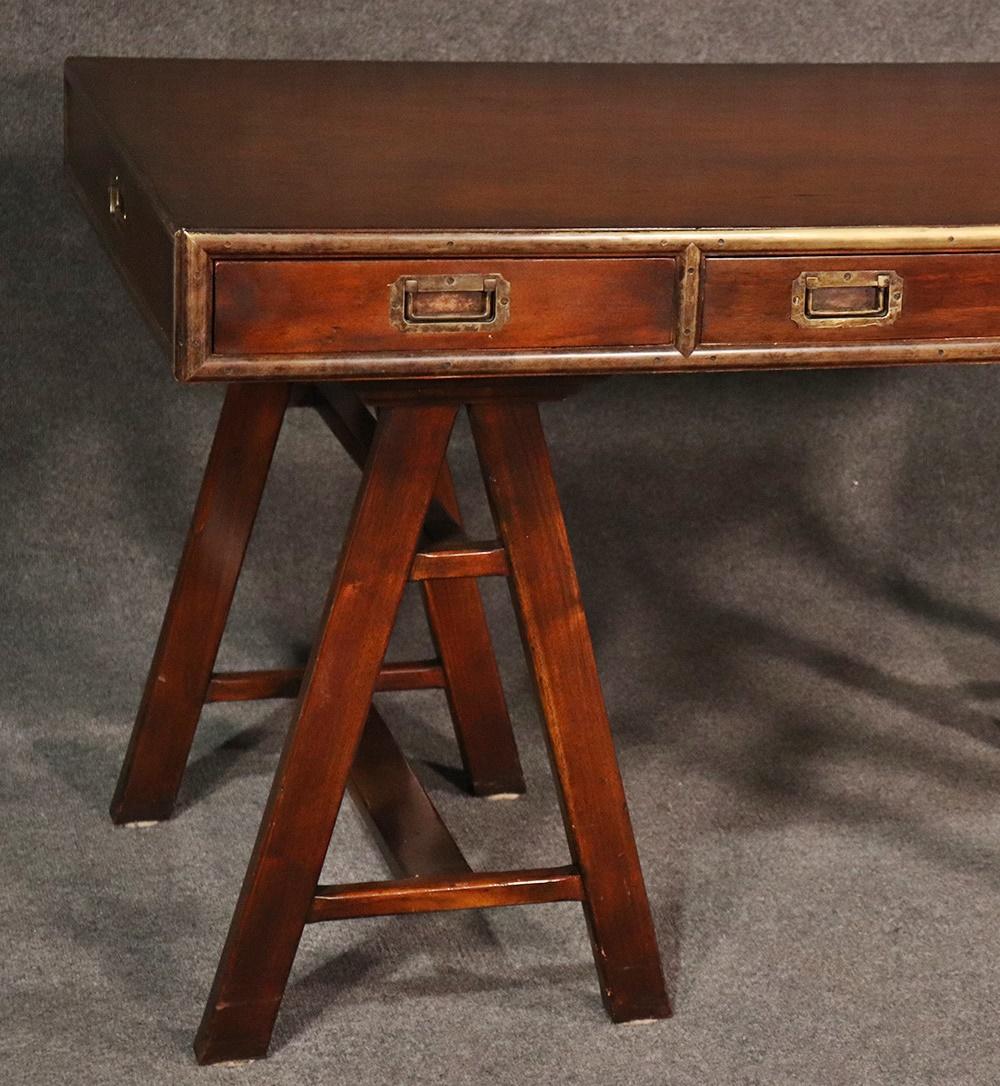 English solid mahogany and brass trimmed Campaign style desk with recessed screws and dovetailed drawers. Don't be fooled by the simple lines and relatively sleek design, this is a heavy solid mahogany desk. The desk is a fantastic reproduction of