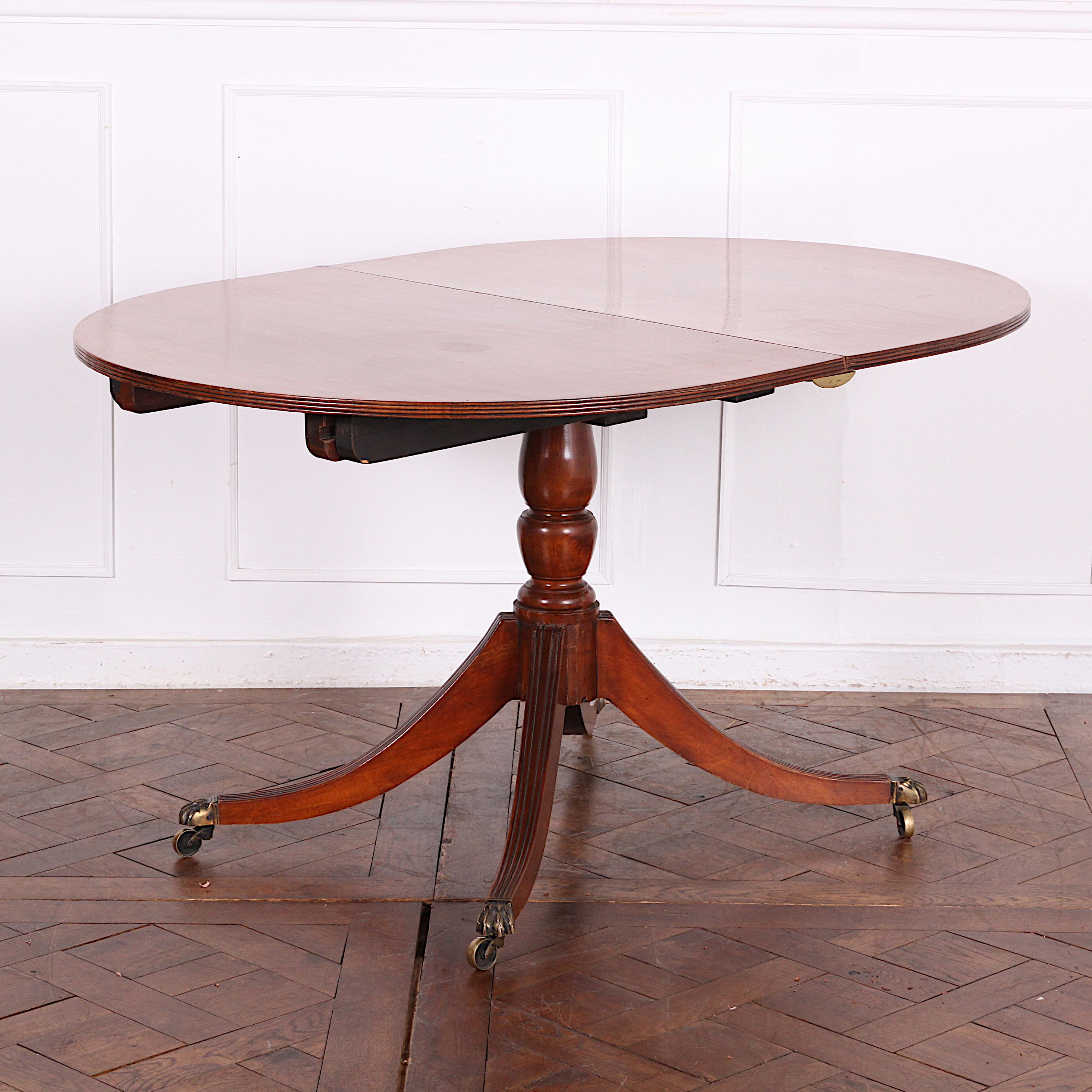An English Georgian-revival single pedestal mahogany dining table with one leaf. The top and leaf of solid mahogany planks, the base with turned column and four out-swept sabre legs with their original brass castors. C. 1920


  
