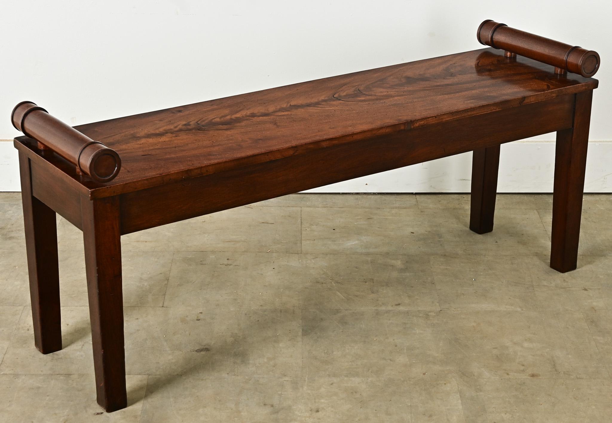 Ce banc d'entrée, ou siège de fenêtre, du XIXe siècle, originaire d'Angleterre, est d'une qualité irréprochable, depuis le fraisage de l'acajou jusqu'à la profondeur des couleurs. Les bras uniques en bois sculpté en forme de tonneaux sont la