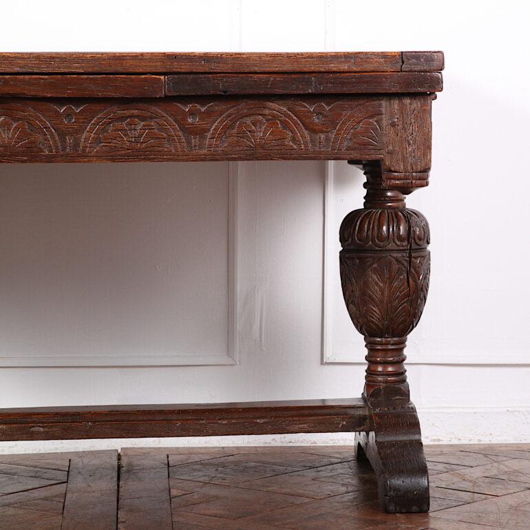 English solid oak 17th century style carved draw-leaf table, the solid oak top and leaves resting on a heavily-carved apron, the whole raised on turned and carved baluster-turned legs. 19th century construction in a 17th century style.

This table