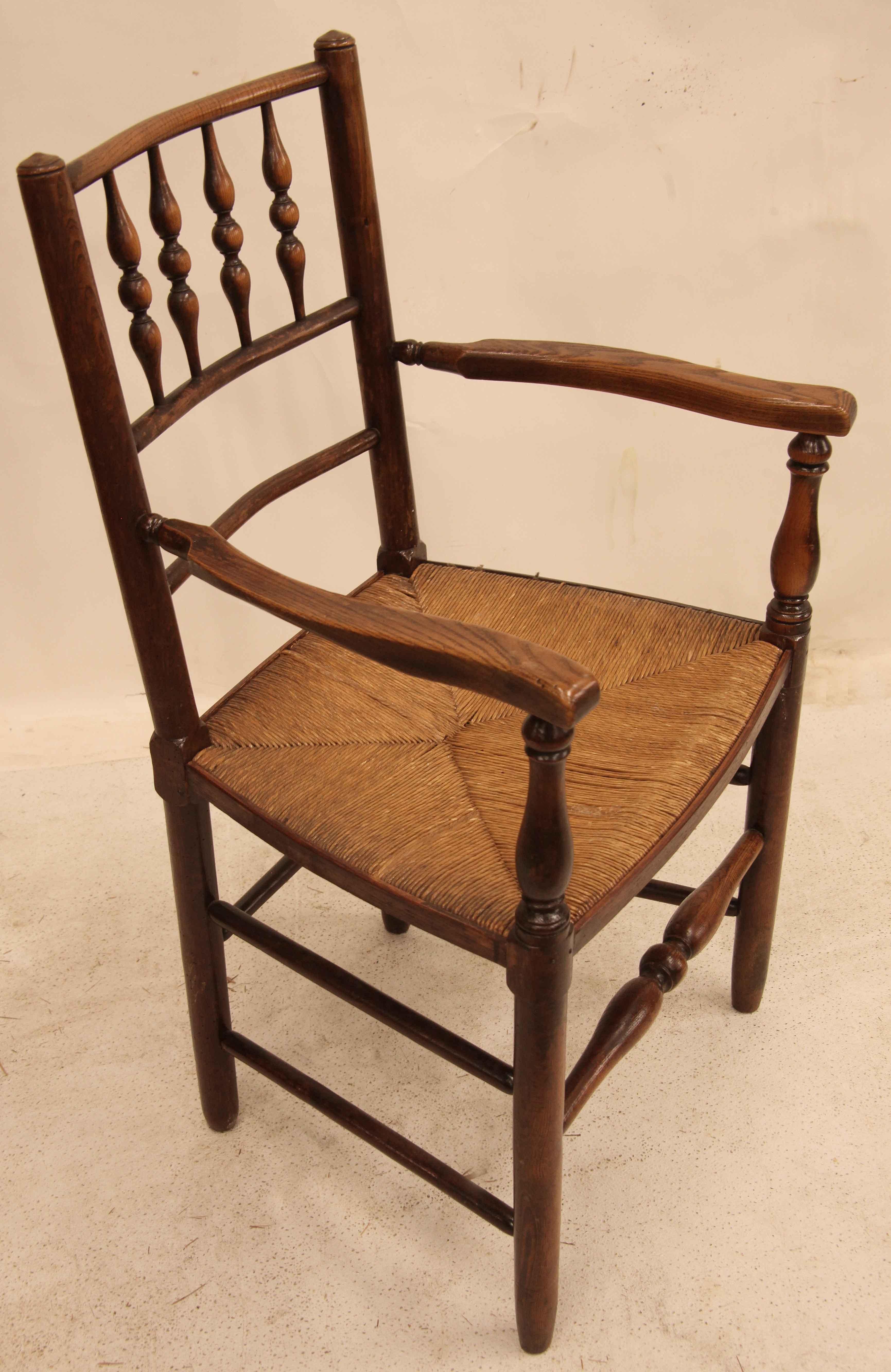 English spindle back chair,  the back is shaped for a very comfortable sitting, original rush seat, the arms and spindles have a beautiful patina that comes from decades of use.  There are single and double stretchers around the perimeter of the