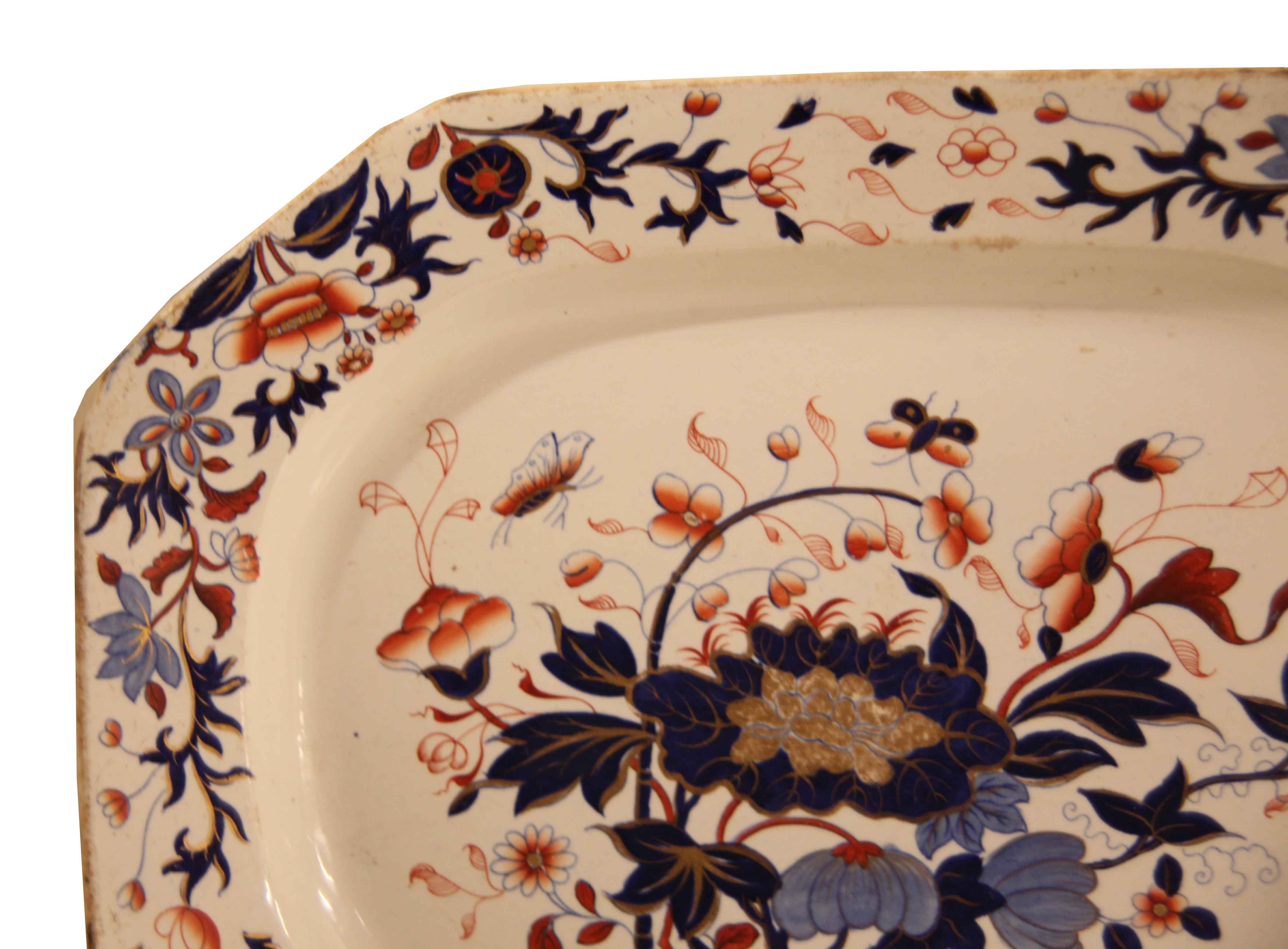 English Spode Ironstone Platter, this platter has an octagonal shape with a slight ''pinch'' at each angle point. The border features a repeating pattern of flowers and foliate with various shades of orange, coral, cobalt, brown, and light blue