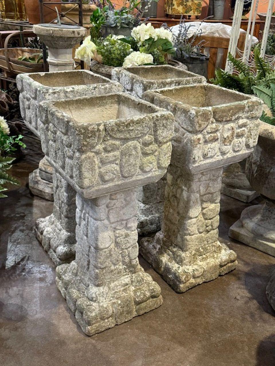 A set of four handsome English garden planter pots - each planter featuring a square top over a sqaure column pedestal mounted to a square plinth base - with a cobblestone or masonry rubble relief.

Four available - Individually priced - $1895 each