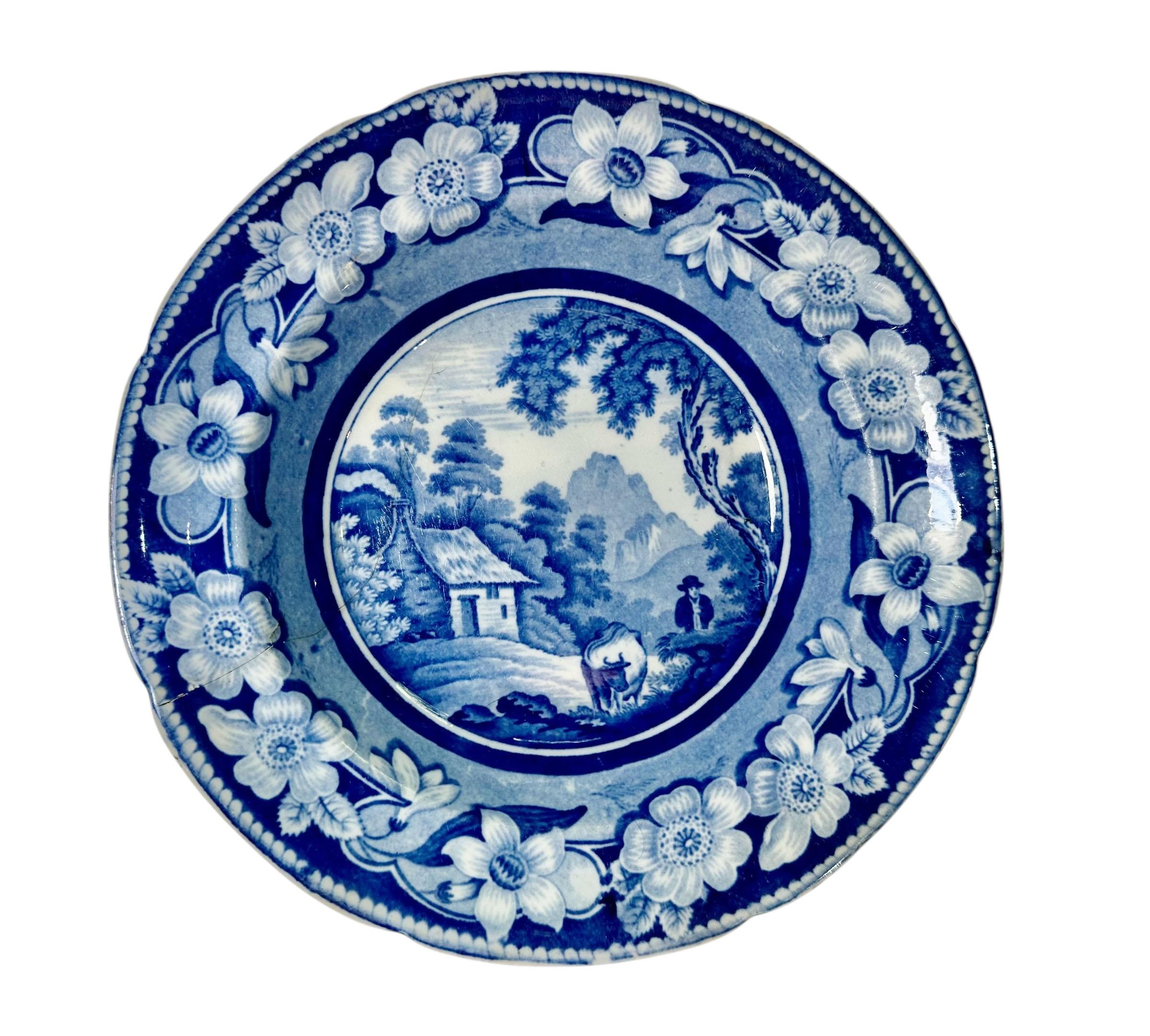 Ein charmantes Paar blauer und weißer Staffordshire-Teller aus dem frühen 19. Jahrhundert, datiert auf ca. 1825. Bekannt als der Mann mit der Kuh, zeigt jeder Teller eine pastorale Szene in satten Kobalttönen mit einer dekorativen Blumenbordüre.