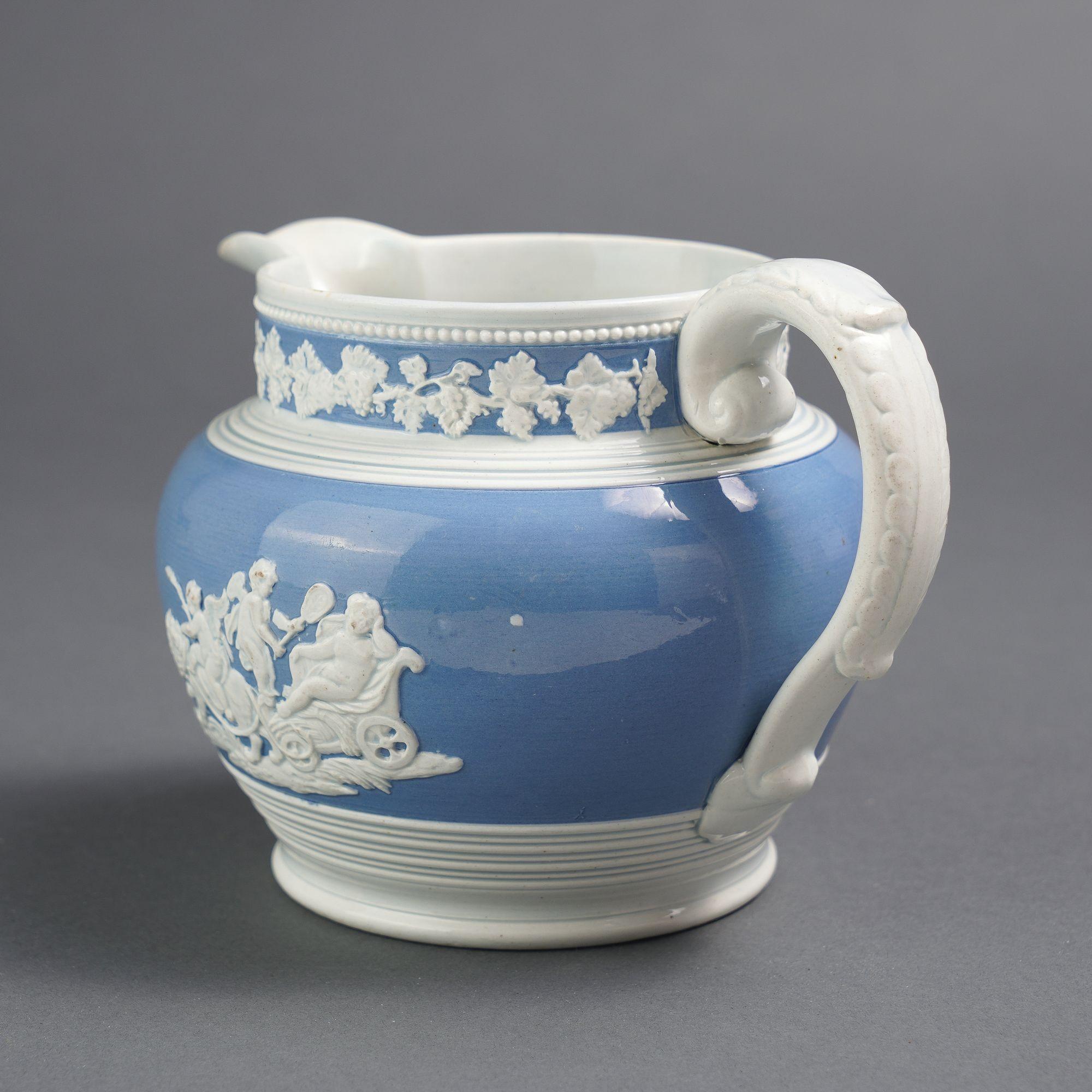 English Staffordshire cider jug with pearlware glaze with light blue band with applied grape vine springs encircling the standing rim between the spout & applied handle. Below below the rim and the reeded shoulder is another light blue enamel band
