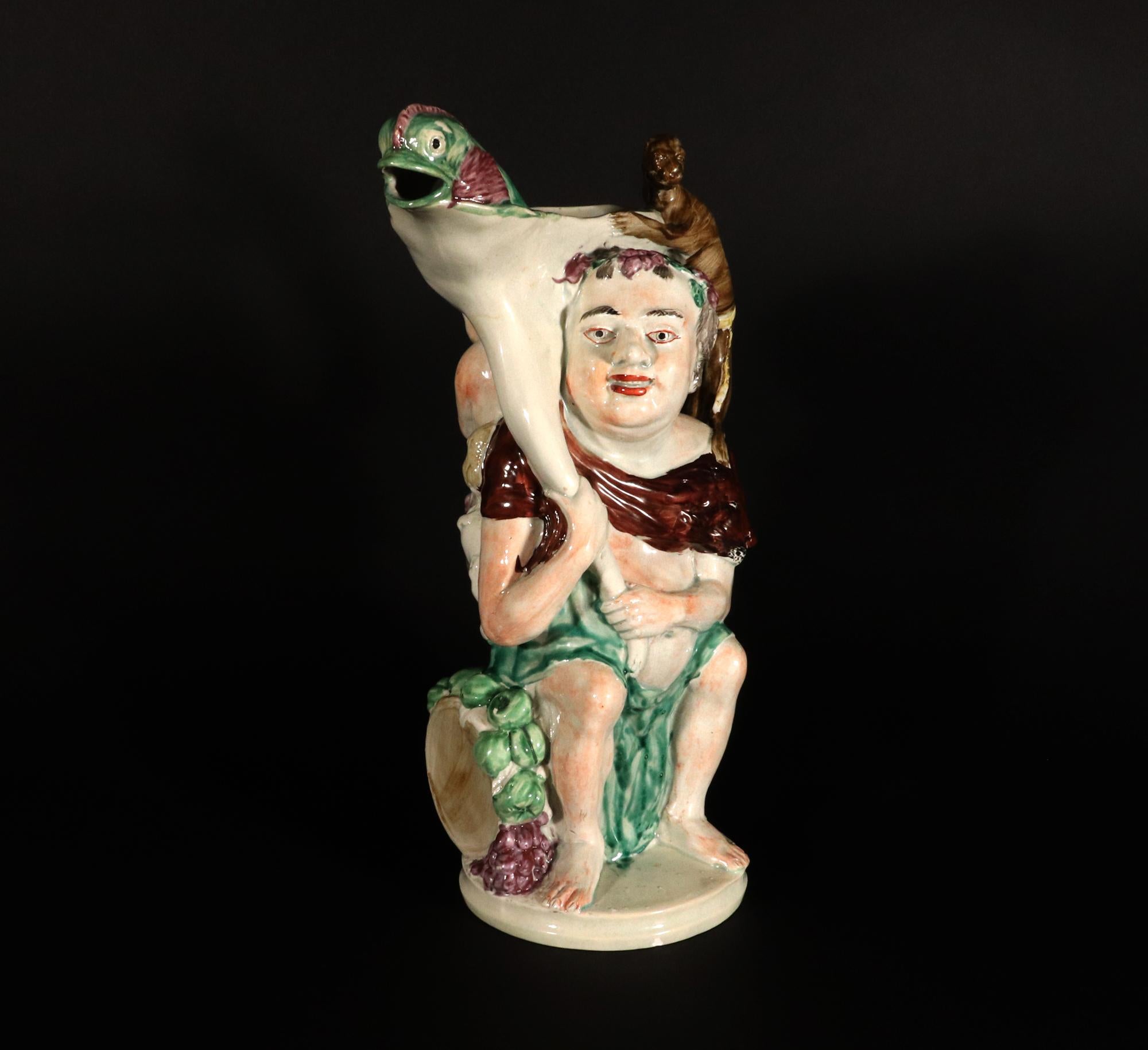 Jarra grande Bacchus de cerámica inglesa Pearlware,
Staffordshire,
Alrededor de 1800

La jarra grande de cerámica Pearlware representa a Baco sentado en un tonel, con una gran cornucopia sobre el hombro derecho, que luego forma el labio de la jarra.
