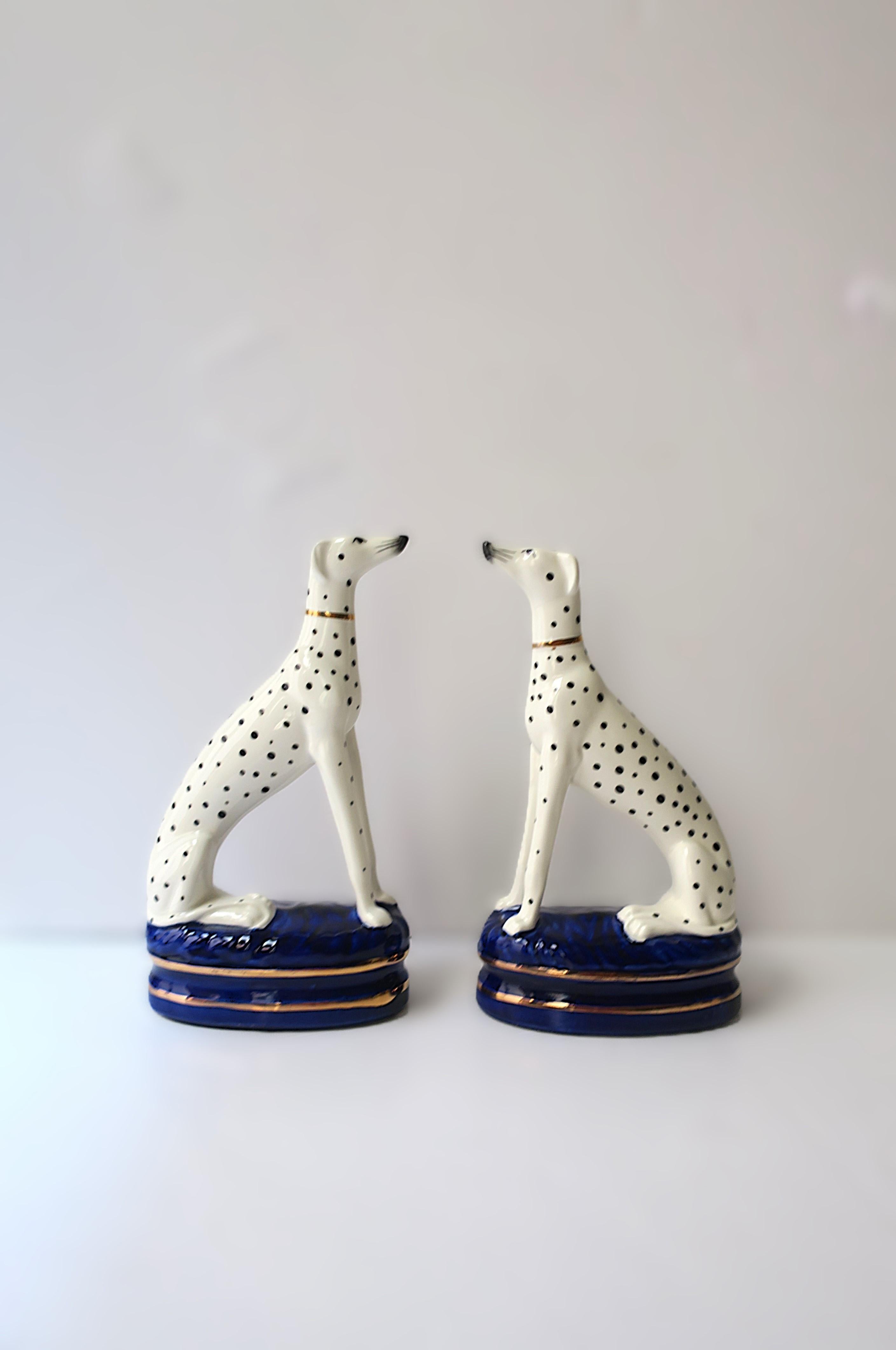 A regal pair of black and white porcelain greyhound, whippet, or dalmatian dog decorative objects or bookends, in the English Staffordshire style, circa late-20th century. This pair of decorative porcelain sculptures or bookends have beautiful, tall