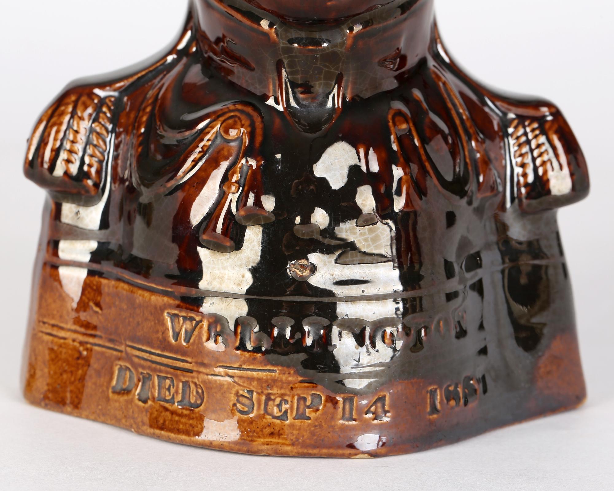 A fine English Staffordshire treacle glazed pottery jug commemorating the death of Wellington on September 14, 1852. The jug is modelled as a bust of Wellington in military uniform with his tricorn hat forming the pouring spout. The bust sits on a