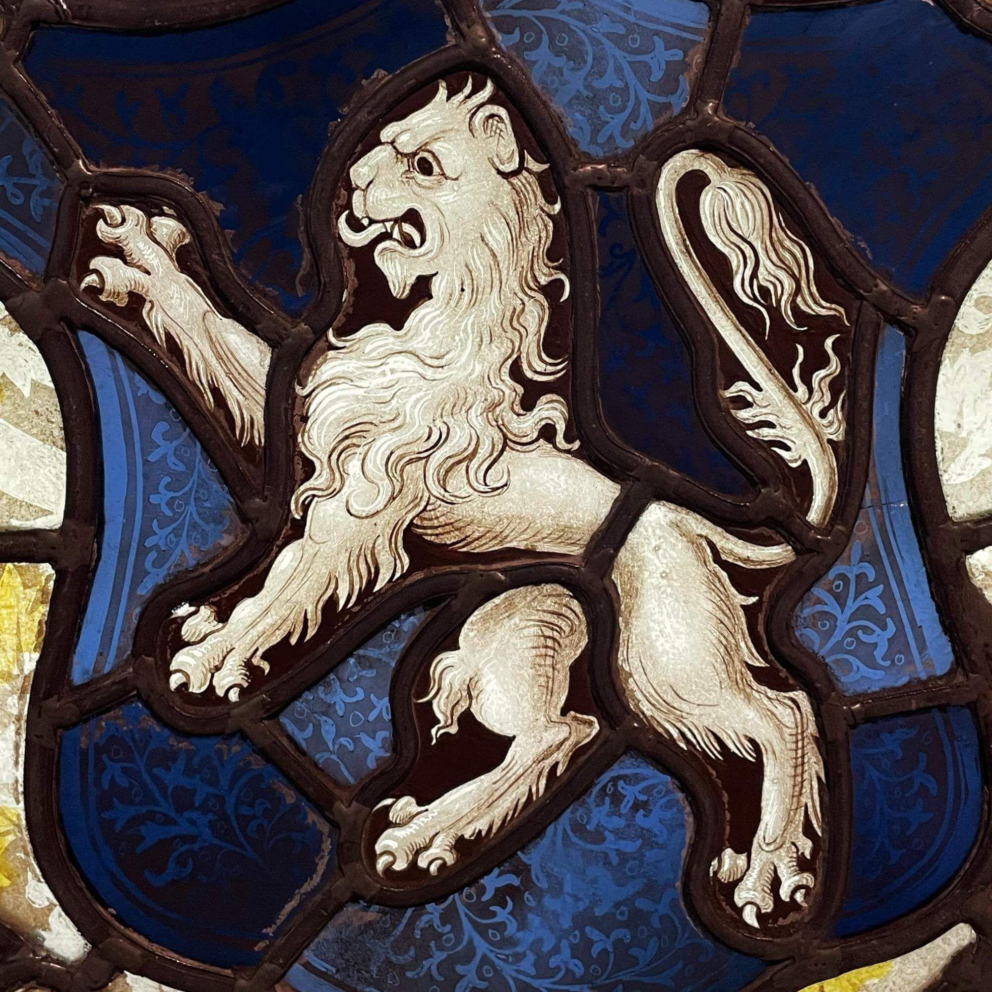 Vitrail anglais ancien de style Tudor représentant les armoiries de la famille Morley, datant d'environ 1820. Cette superbe cocarde est délicieusement détaillée, l'écu central bleu portant un lion rampant entouré de feuillage vert, de fleurs bleues,