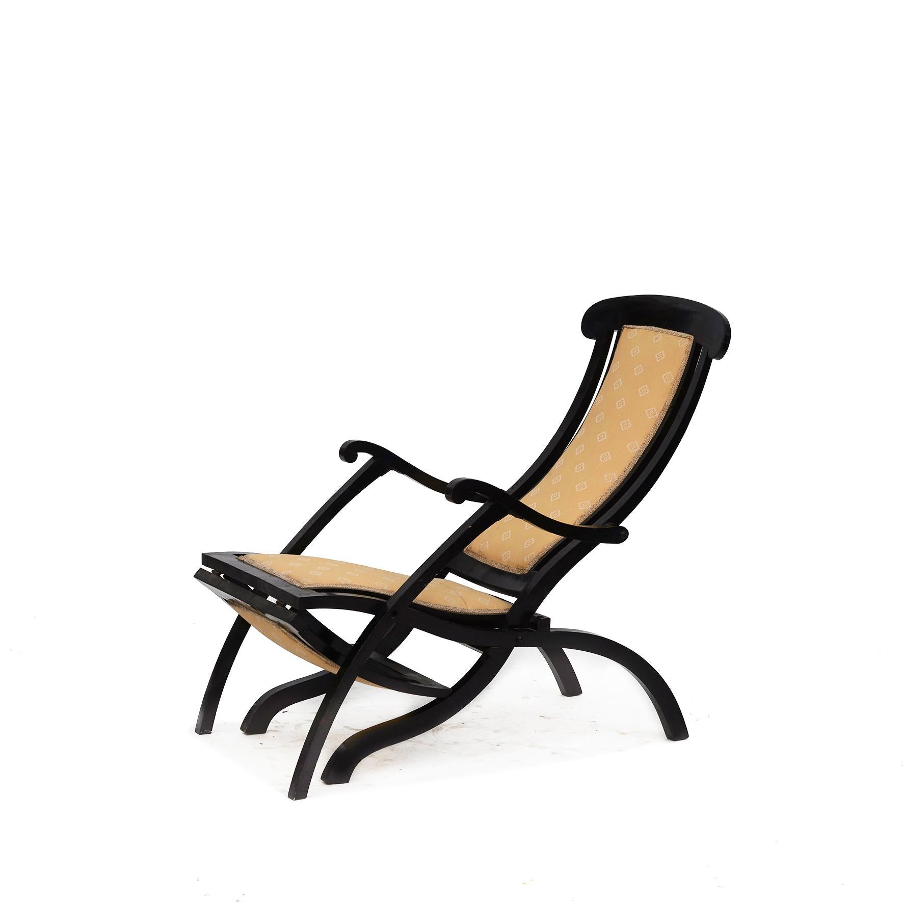 English Steamer folding deck chair with extending footrest.
Frame in black lacqured wood with upholstered seat, back and footrest. Upholstery with age-related wear.

Soft shaped with its scrolling arms and splayed legs
