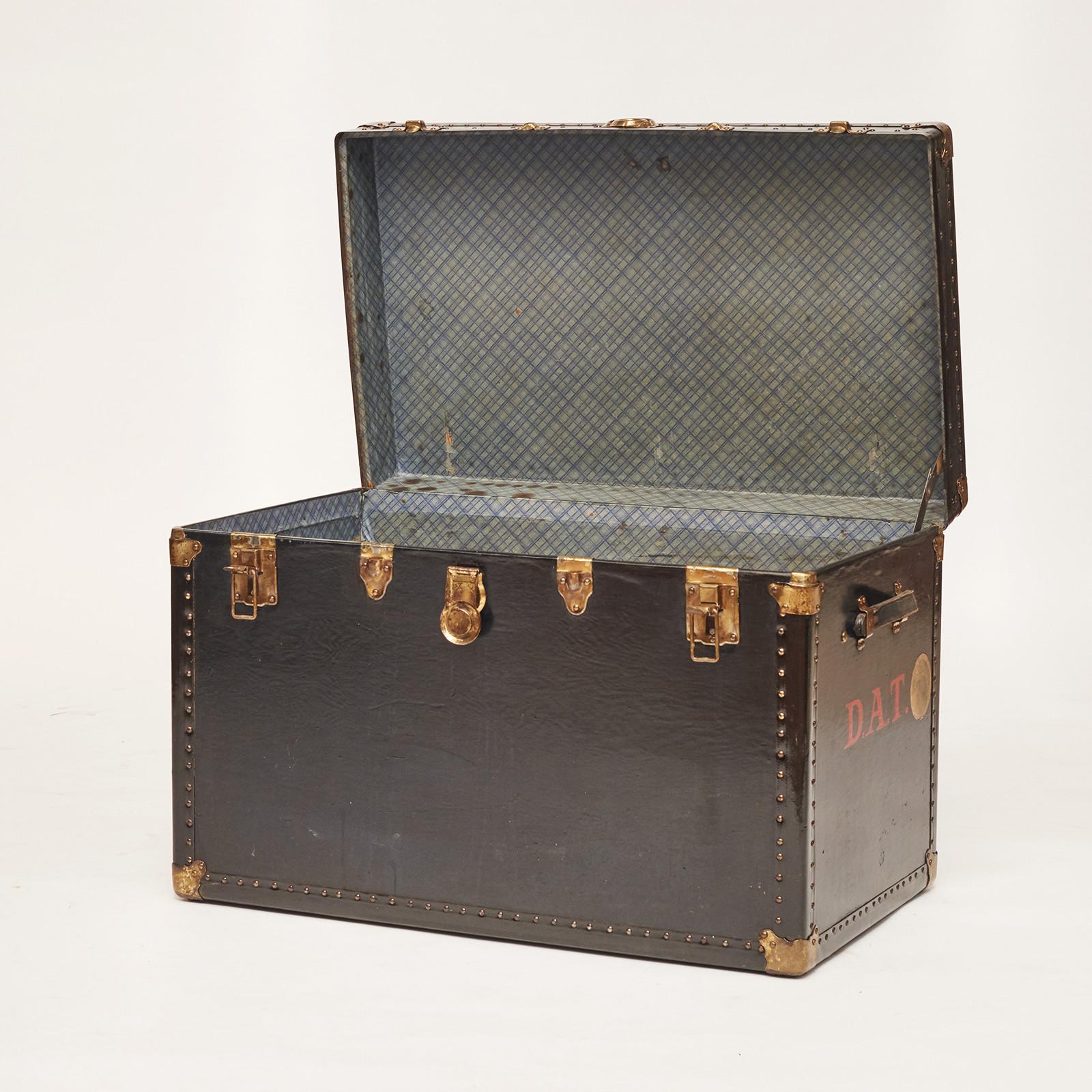 English travel trunk. Constructed with a base trunk box made of wood covered with black and blue coated canvas. The interior is covered with patterned paper. Brass fittings.
Original condition, England, 1900-1920.