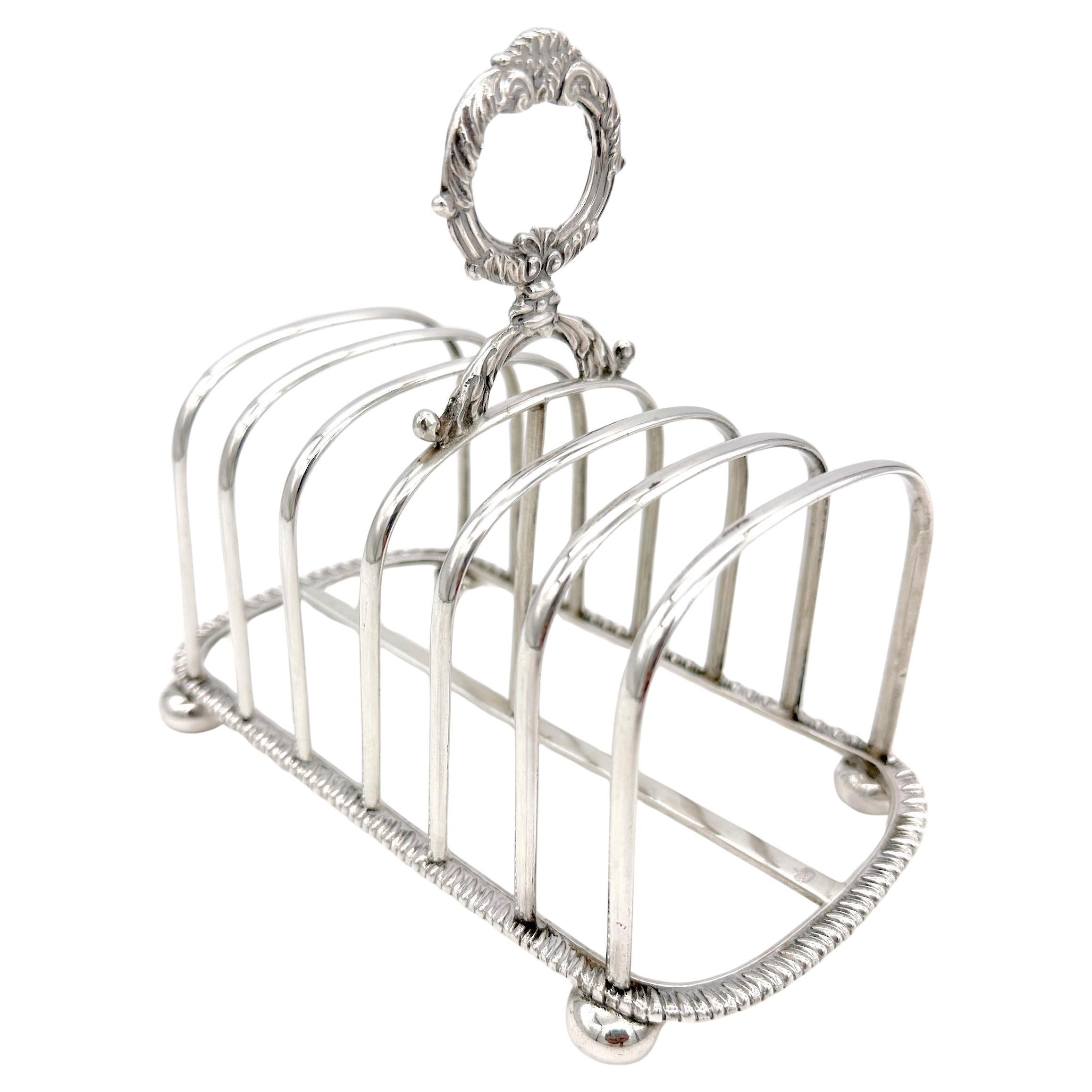 Portacartas o tostador inglés de plata esterlina, Londres, 1900, Johnson, Walker & Tolhurst 

Este exquisito cartapacio o tostador inglés de plata de ley fue fabricado por la estimada Johnson, Walker & Tolhurst y ensayado en Londres en 1900. La