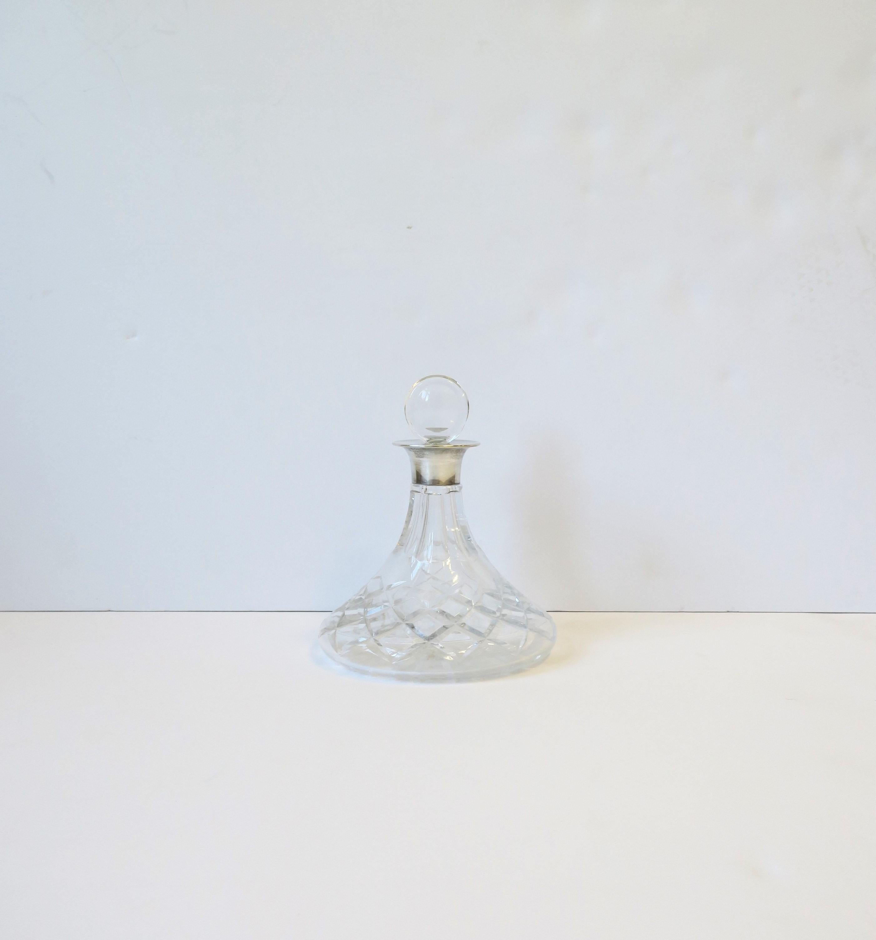 An English sterling silver and crystal spirits decanter, circa 20th century, England. A beautiful cut crystal spirits decanter with silver mount and crystal stopper. Decanter is a convenient size too measuring 5.63