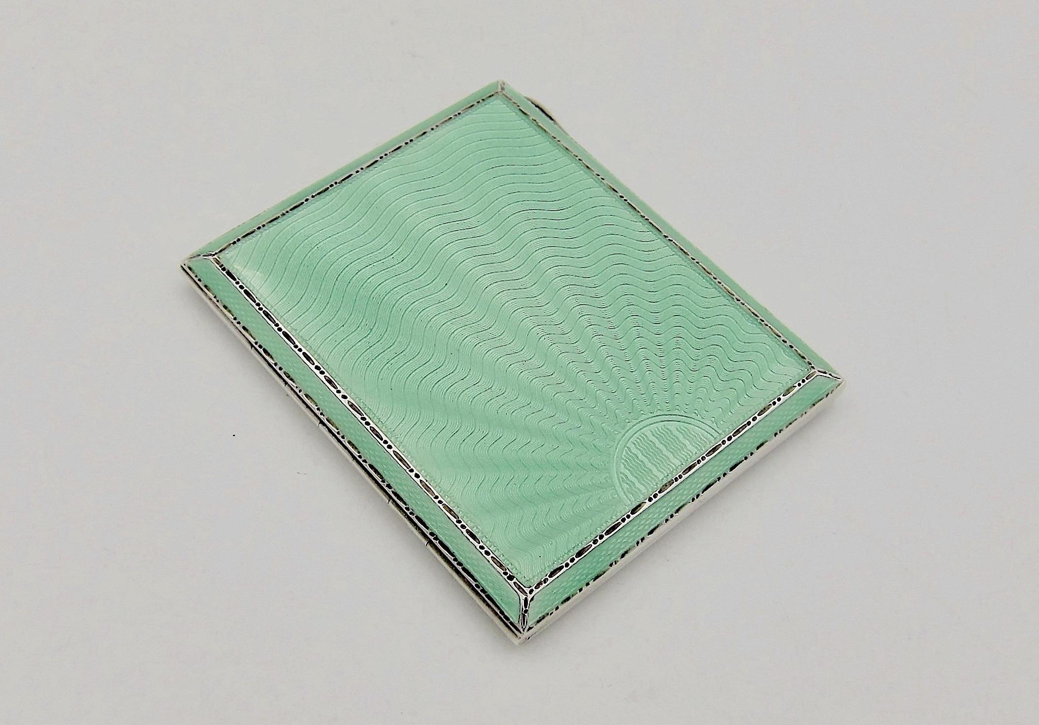 An English Art Deco cigarette case in sterling silver and green guilloche enamel with a silver gilt interior from Birmingham based silversmiths Adie Brothers Ltd., date marked for 1937. The upper side of the rectangular case is decorated with a