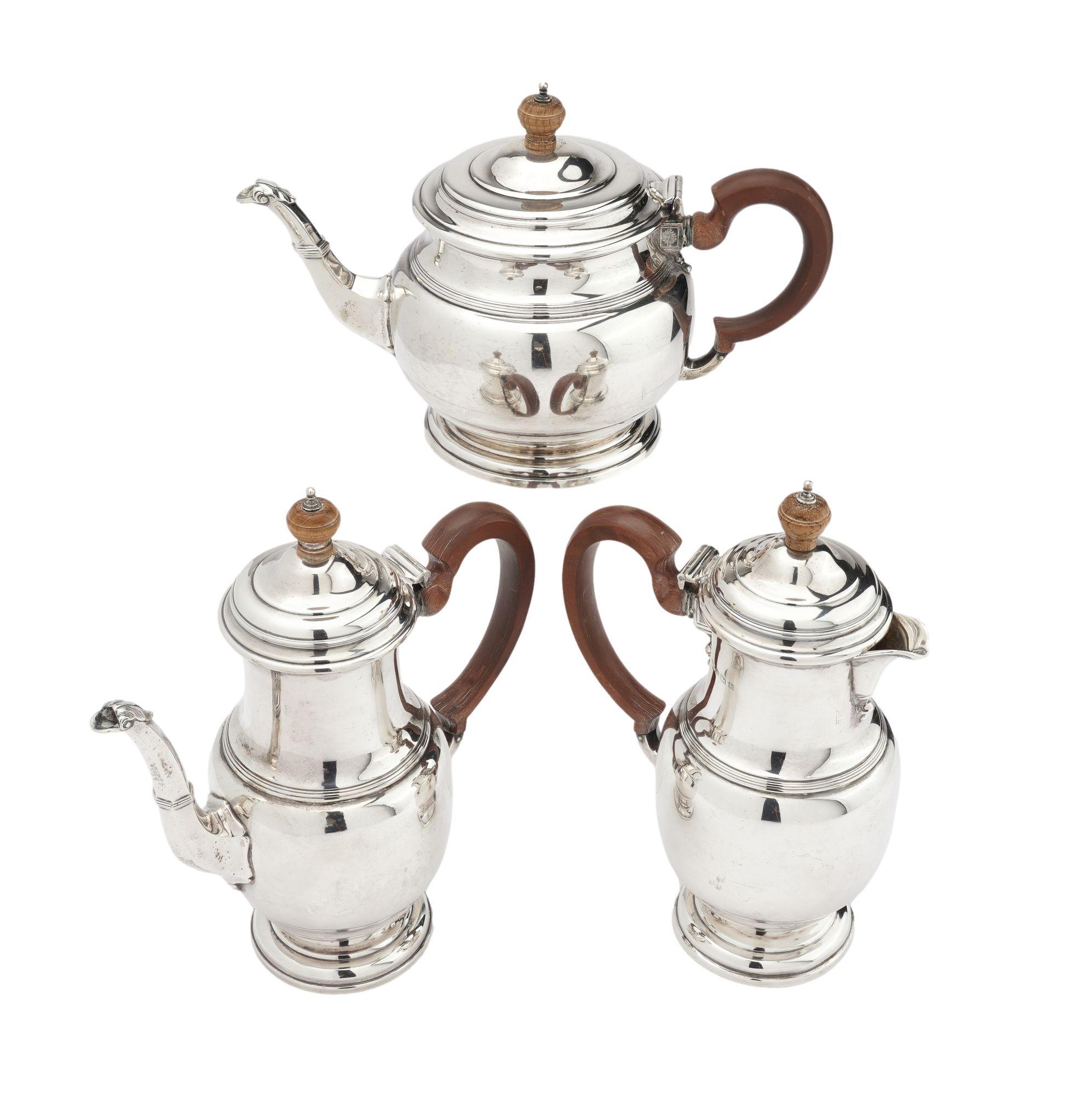 Three piece sterling silver coffee/tea service with a hot water pot. All vessels have carved wood handles and carved wood lid finials. Fine original condition.
Stamped on the underside: Mapin & Webb Ltd
London, England, 1929.

Dimensions: Water Pot: