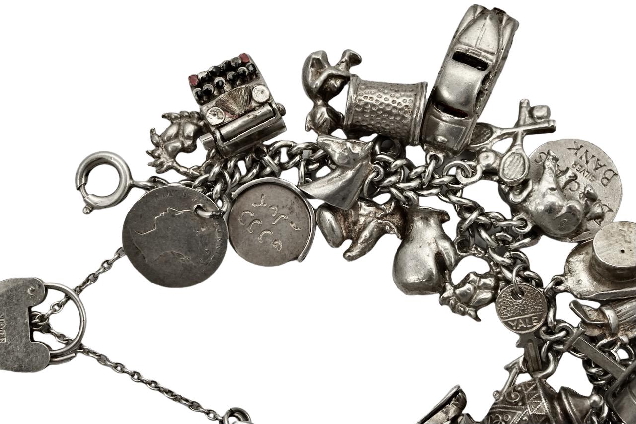 Delightful English sterling silver charm bracelet with a heart lock and safety chain.

There are thirty four charms: telephone, horses head and horseshoe, ballet dancer, owl, horse rider, opening shoe with bride and bridegroom inside, 1940 silver