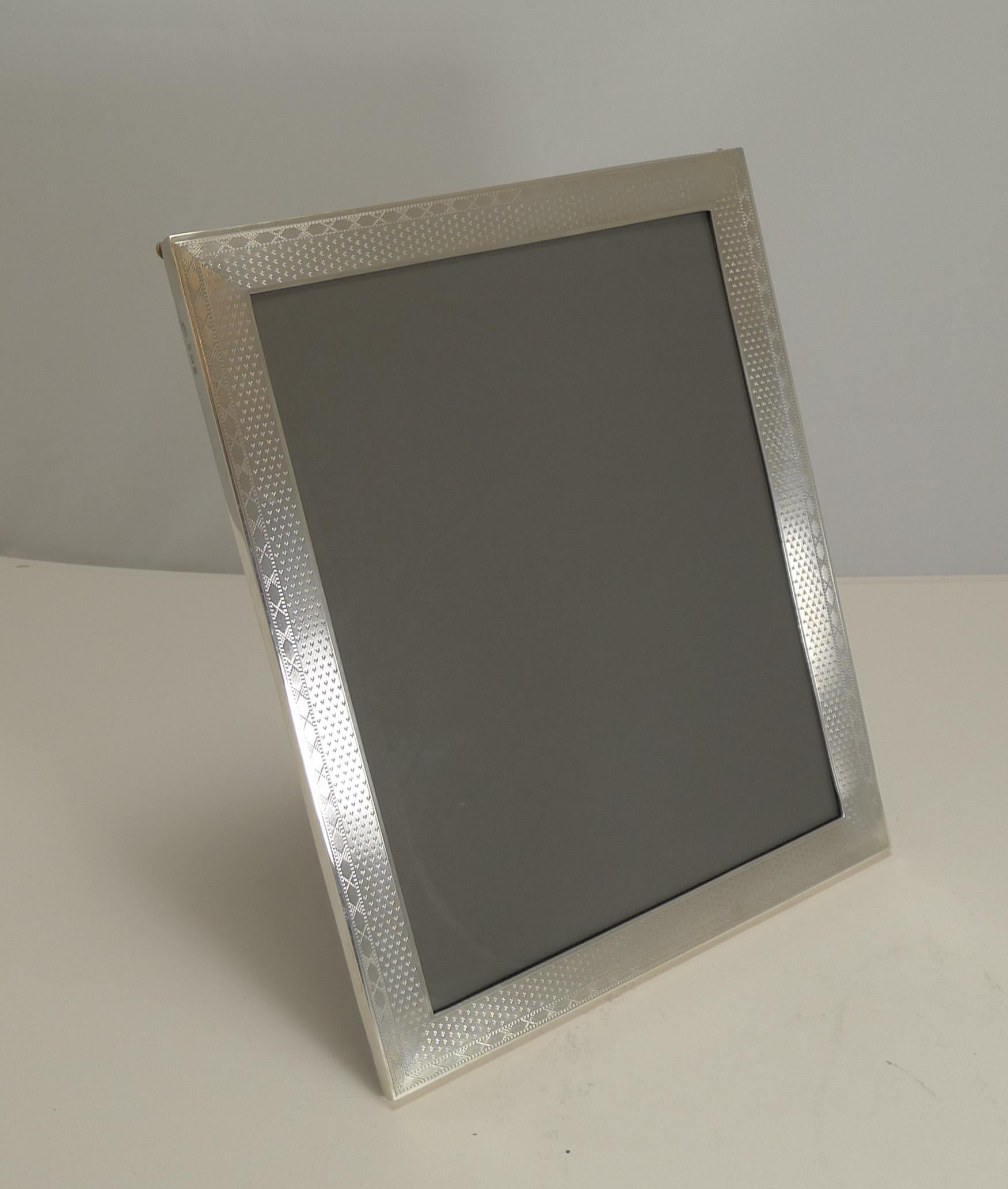 A beautifully elegant photograph frame with a wonderful and unusual engine-turned decoration.

The back is made from solid English Oak incorporating a folding easel stand. The silver is fully hallmarked for Birmingham 1926, Art Deco in era;