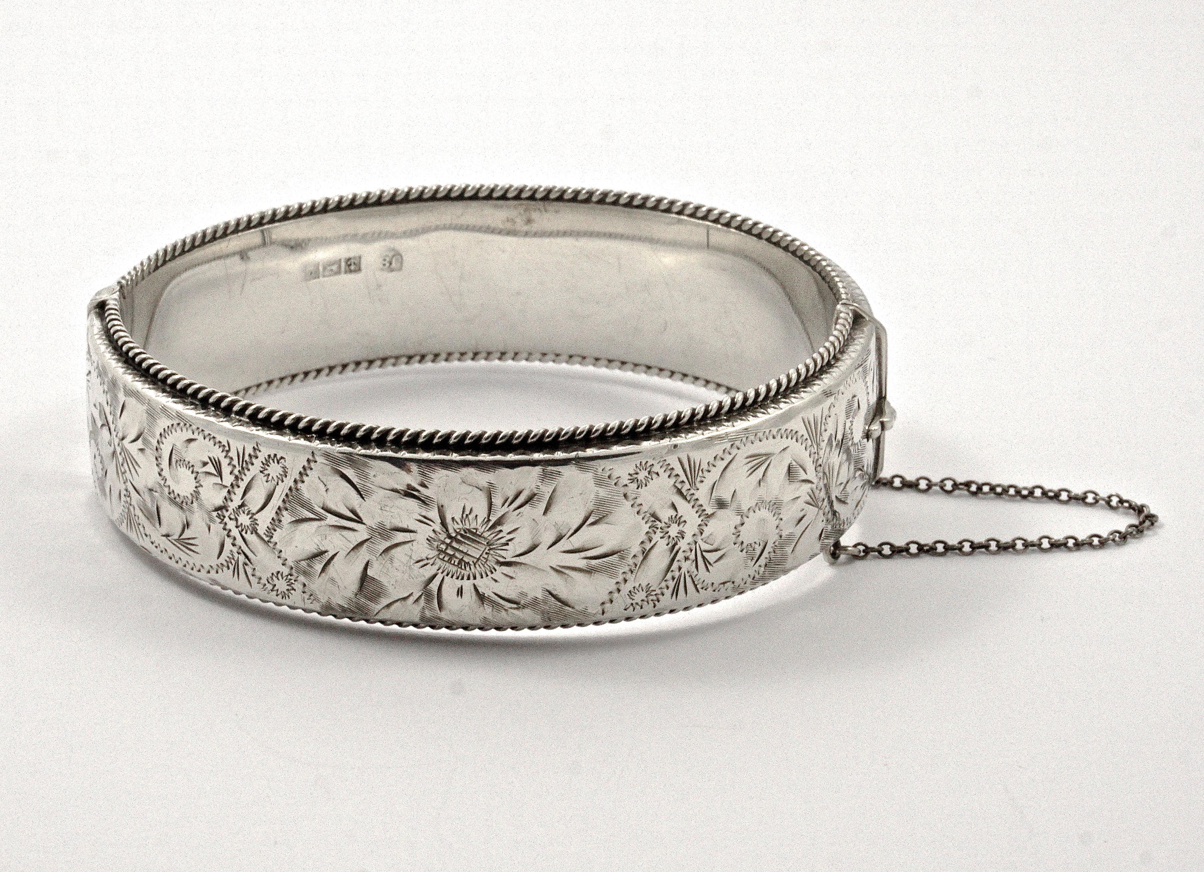 Wonderful sterling silver floral and scroll engraved bangle bracelet with a rope twist edging and a safety chain. It is slightly oval, the inside measurements are 6.4cm / 2.5 inches by 5.5cm / 2.1 inches, and the width is 1.8cm / .7 inch. The