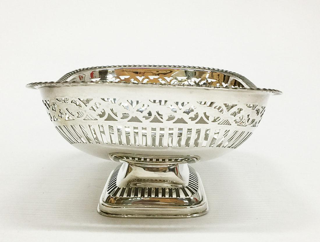 English sterling silver fruit basket by James Deakin & Sons, 1928

A rectangular English silver fruit basket on a base.
A Sheffield sterling silver basket with rounded corners and openwork edges with bars under a repeatedly openwork pattern
The