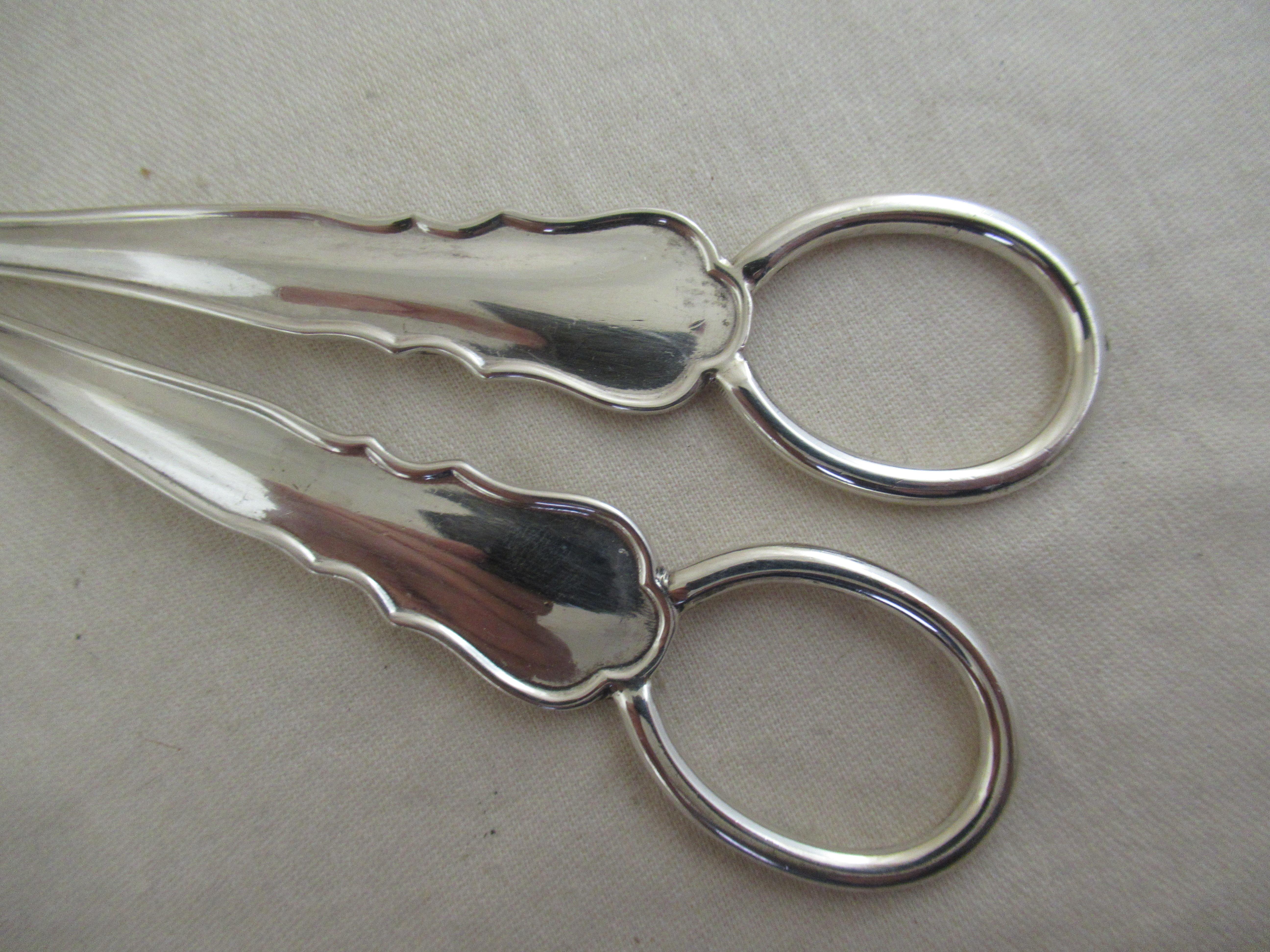 A superb pair of Grape Scissors or shears, made in a variation of  Kings shape. Distinctly raised border, giving extra strength - very sturdy and well made.
Used to cut a bunch of grapes from the vine, but also to grip the cut stem so that the bunch