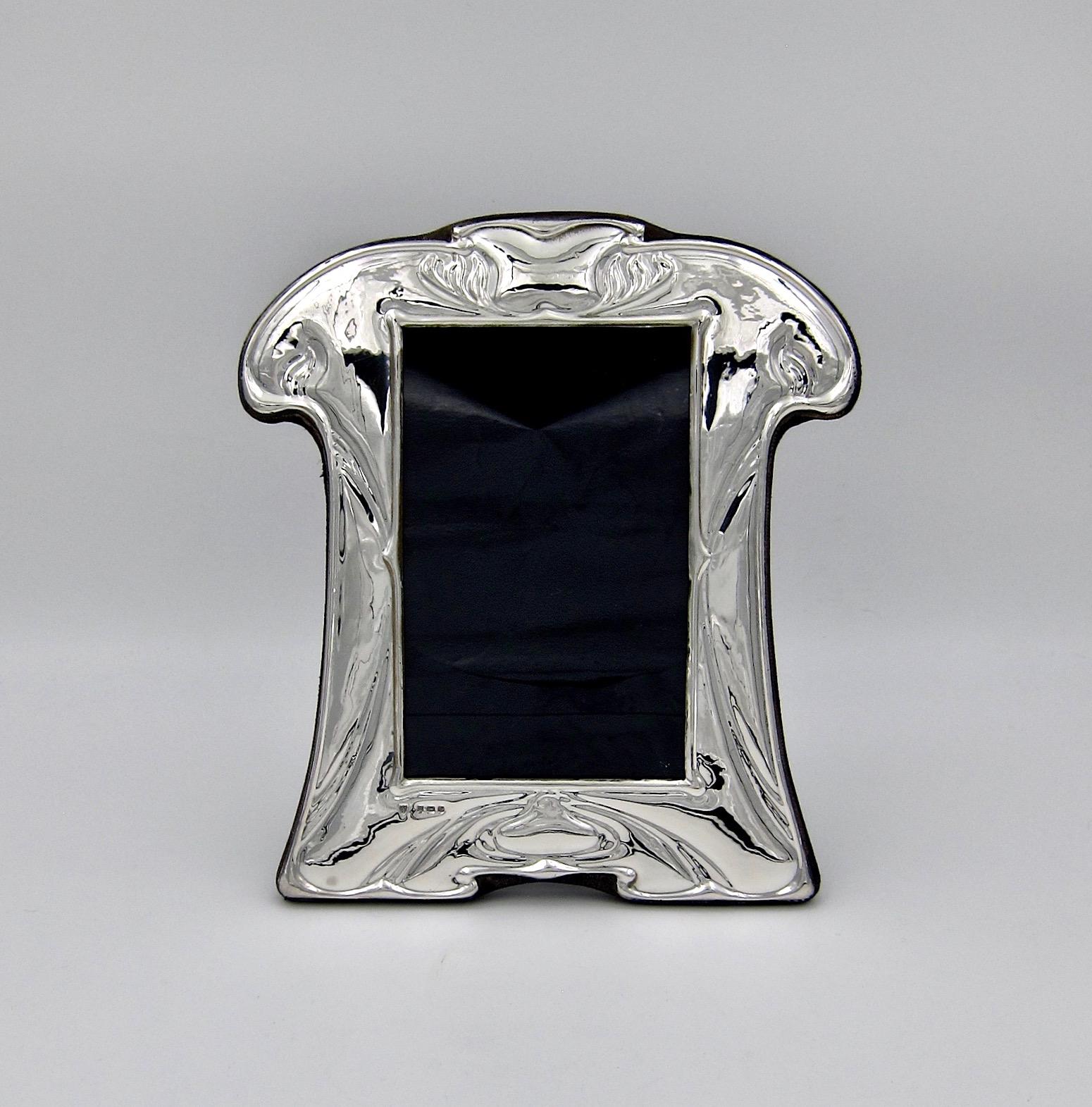 A vintage English picture frame in sterling silver, made in Birmingham and date marked for 1985. This elegant silver photograph frame was designed in the Art Nouveau style and would show beautifully on a mantlepiece, desk, or piano.

The frame