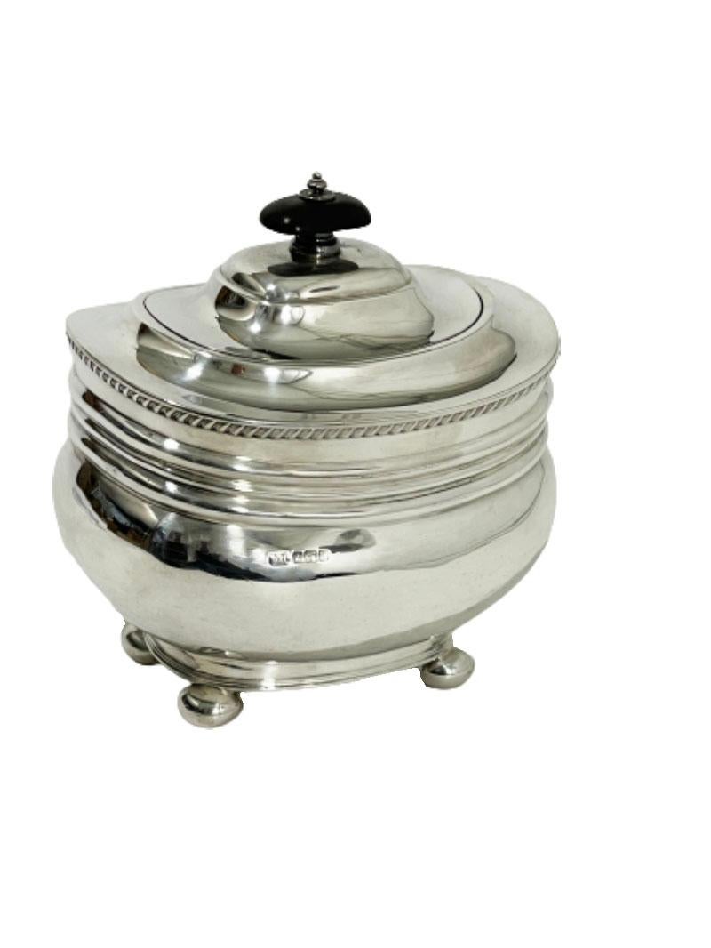 An English silver tea caddy by Harrison Brothers & Howson, Sheffield 1907. 

An oval round shaped silver tea caddy with hinged lid. The caddy raised on a footrim and 4 ball shaped legs. English silver hall marked by Harrison Brothers & George