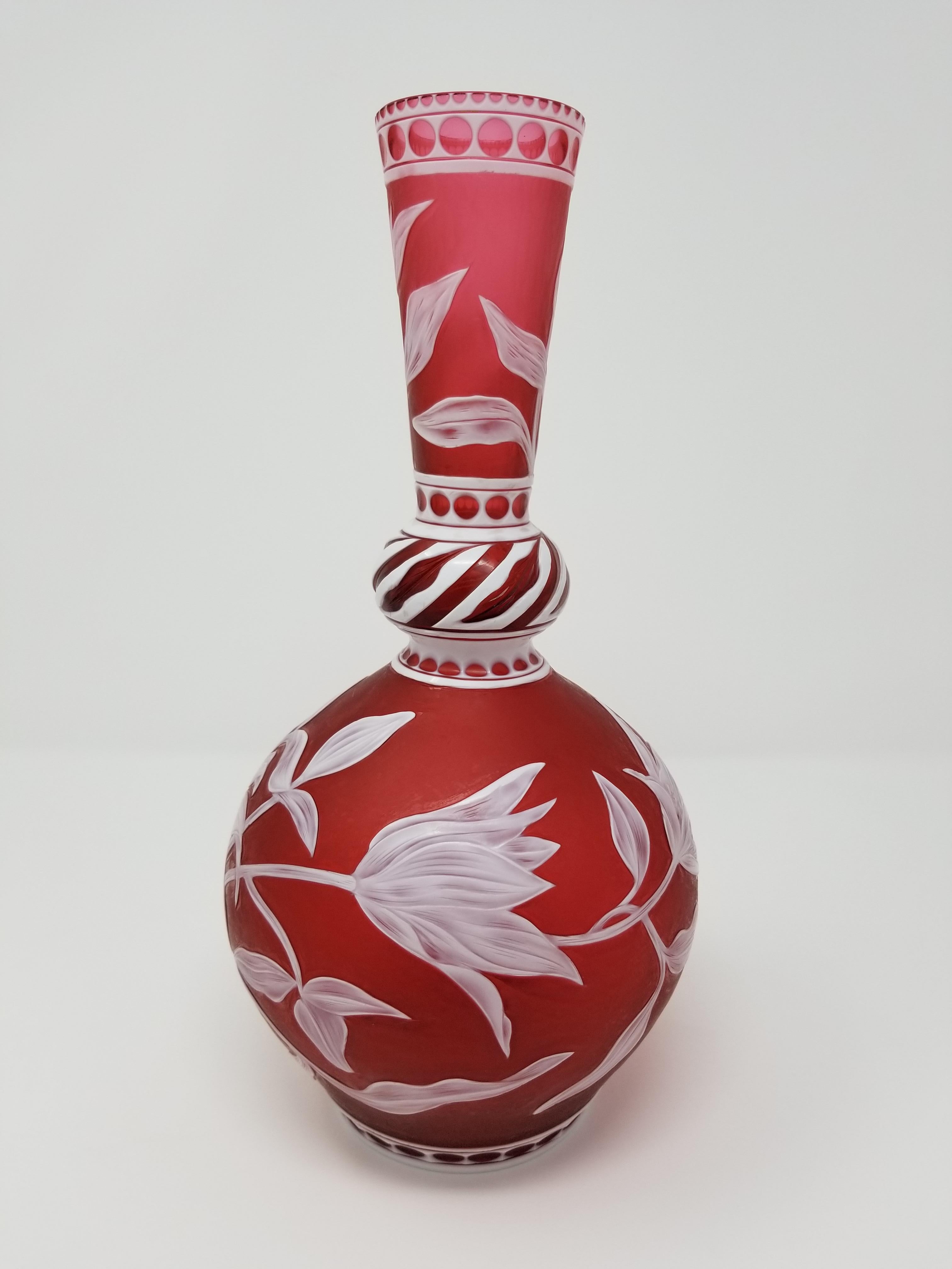 A beautiful English engraved Stevens & Williams red and white overlay cameo glass vase, hand carved, hand-engraved, and hand-etched by J. Millward, signed Stevens & Williams and J. Millward. The vase was created in baluster form with a long bottle