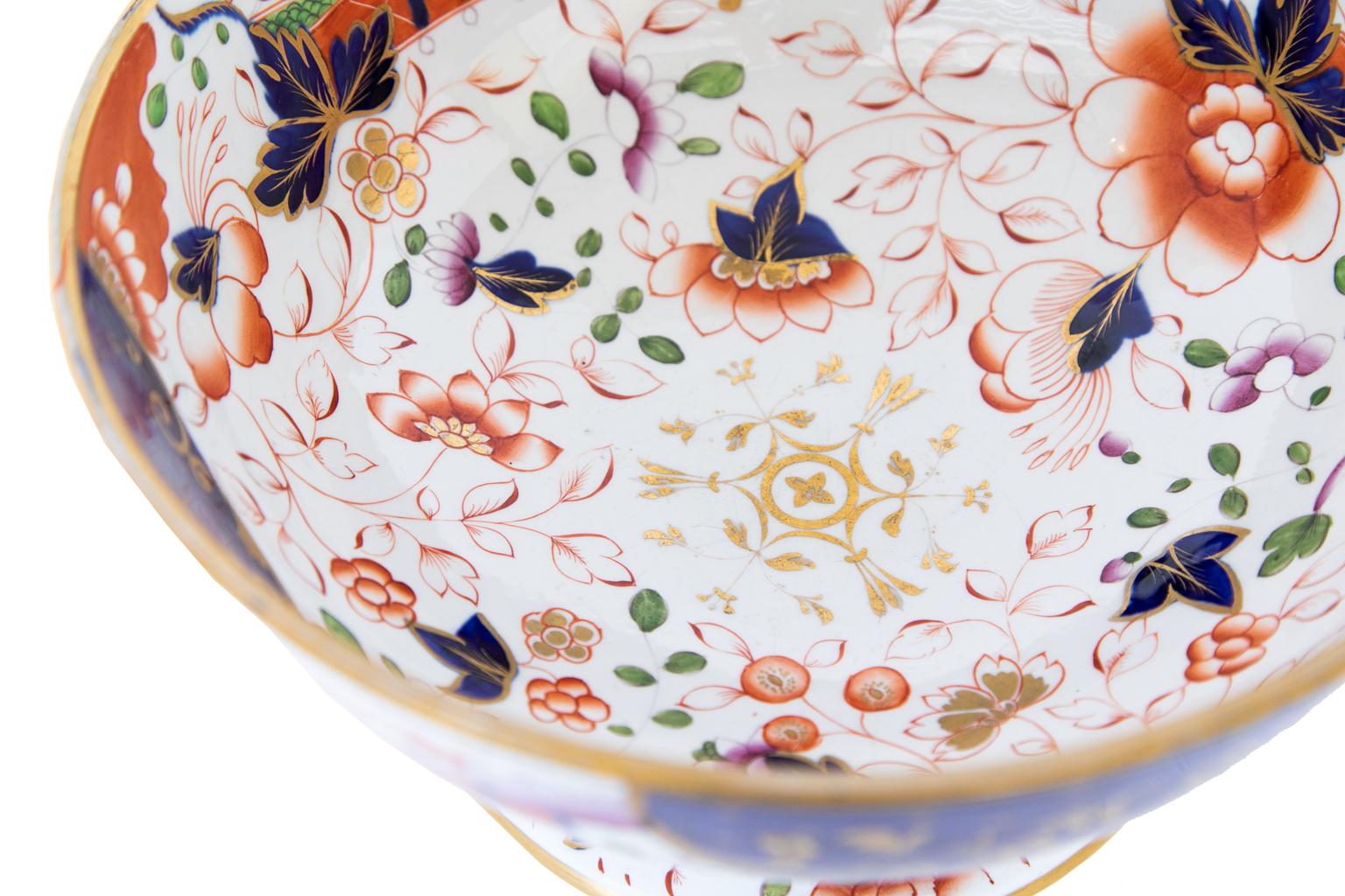 English stone China footed punch bowl, marked Davenport Stone China, Longport , Staffordshire. The floral pattern is red, white, blue, and green mimicking Japanese Imari. The colors are very bold with strong gilt highlights.
  