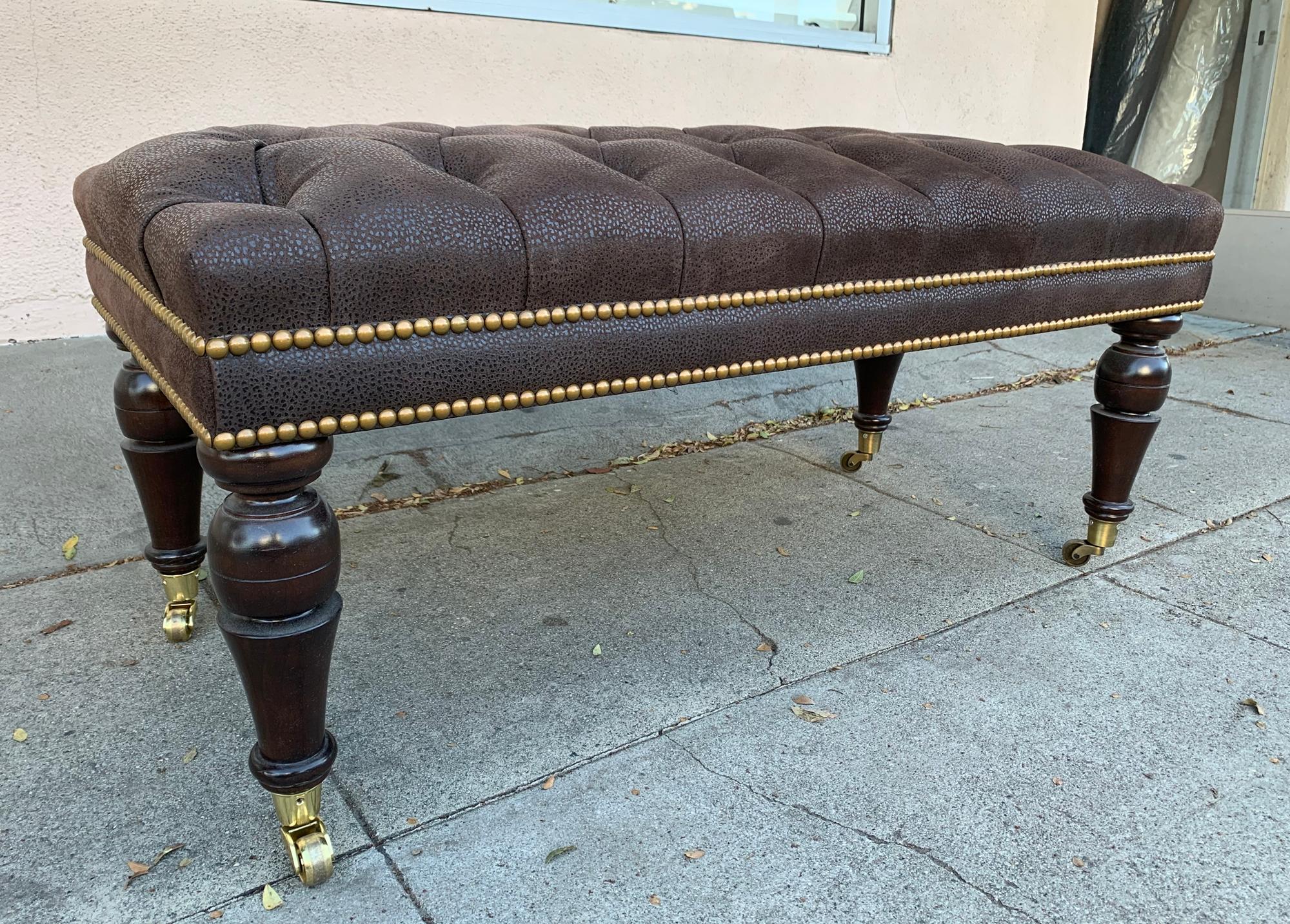Beautiful English style bench with deep tufted leather upholstery and nailhead trimming, the legs are in a dark brown finish, the bench is in casters and is very easy to move, the bench is newly upholstered and refinished and is ready to be