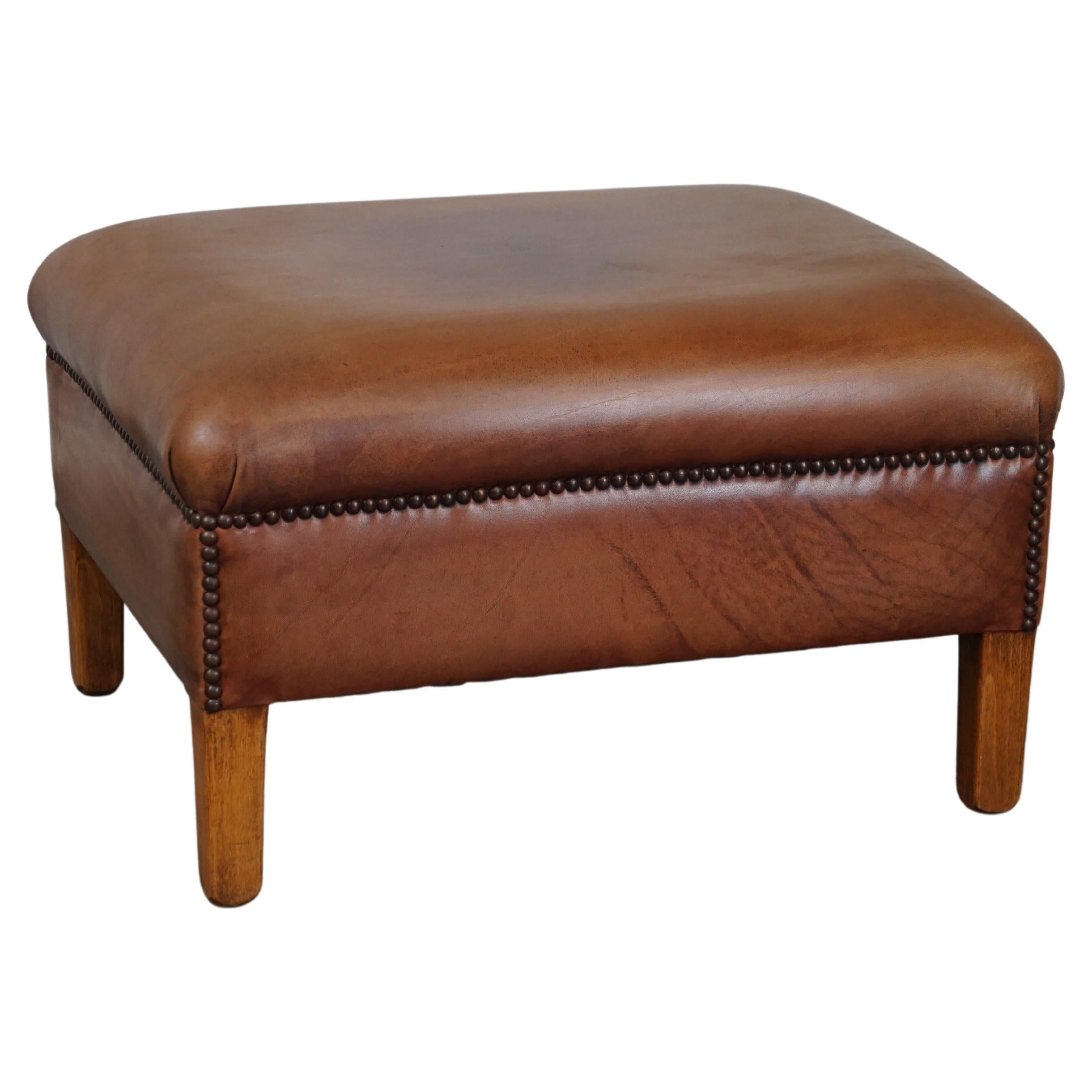 English-style leather ottoman in cognac-colored leather.