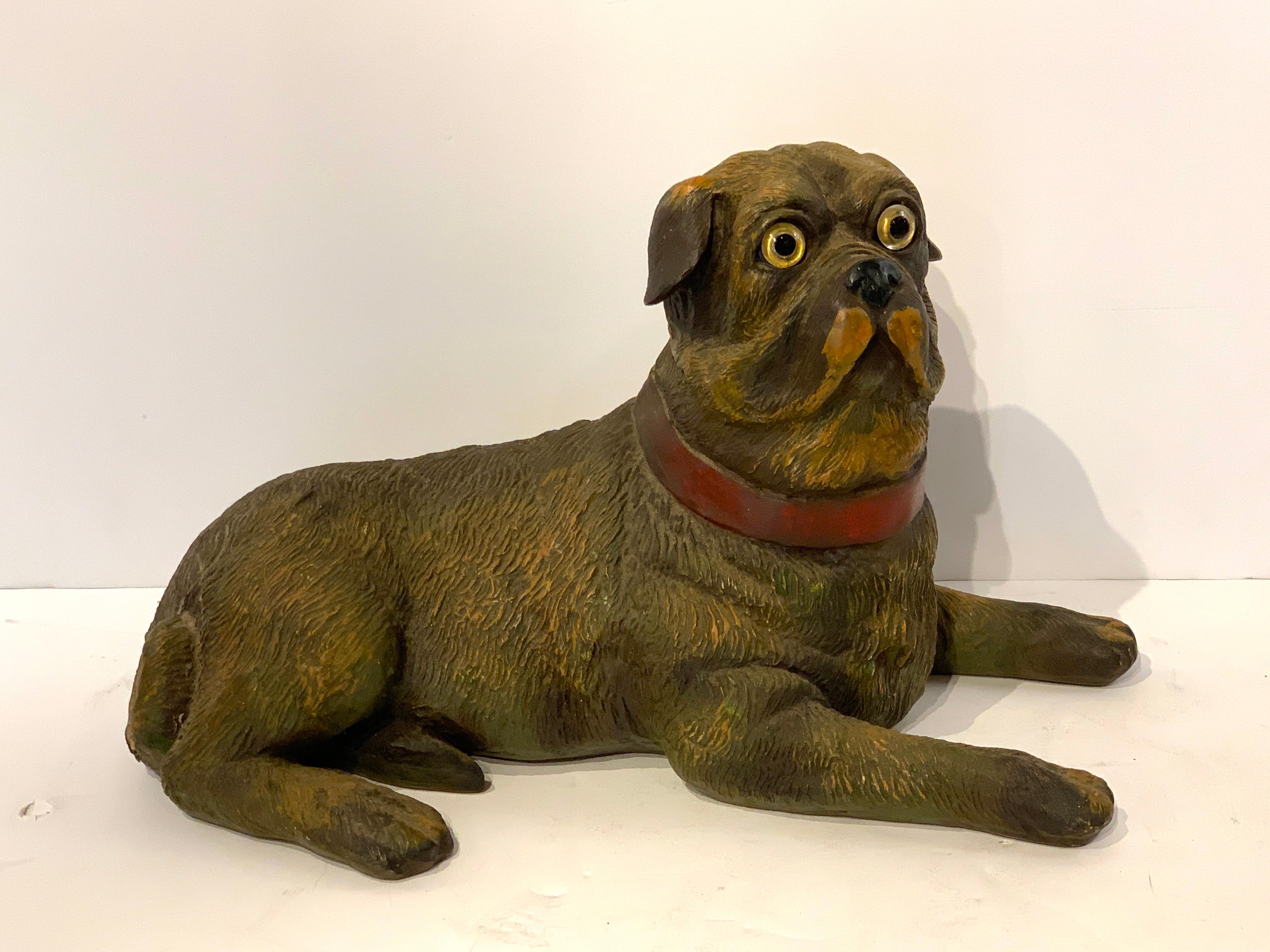 English style recumbent pug dog with glass eyes, realistically cast and modeled decorated composition, resembles terracotta.