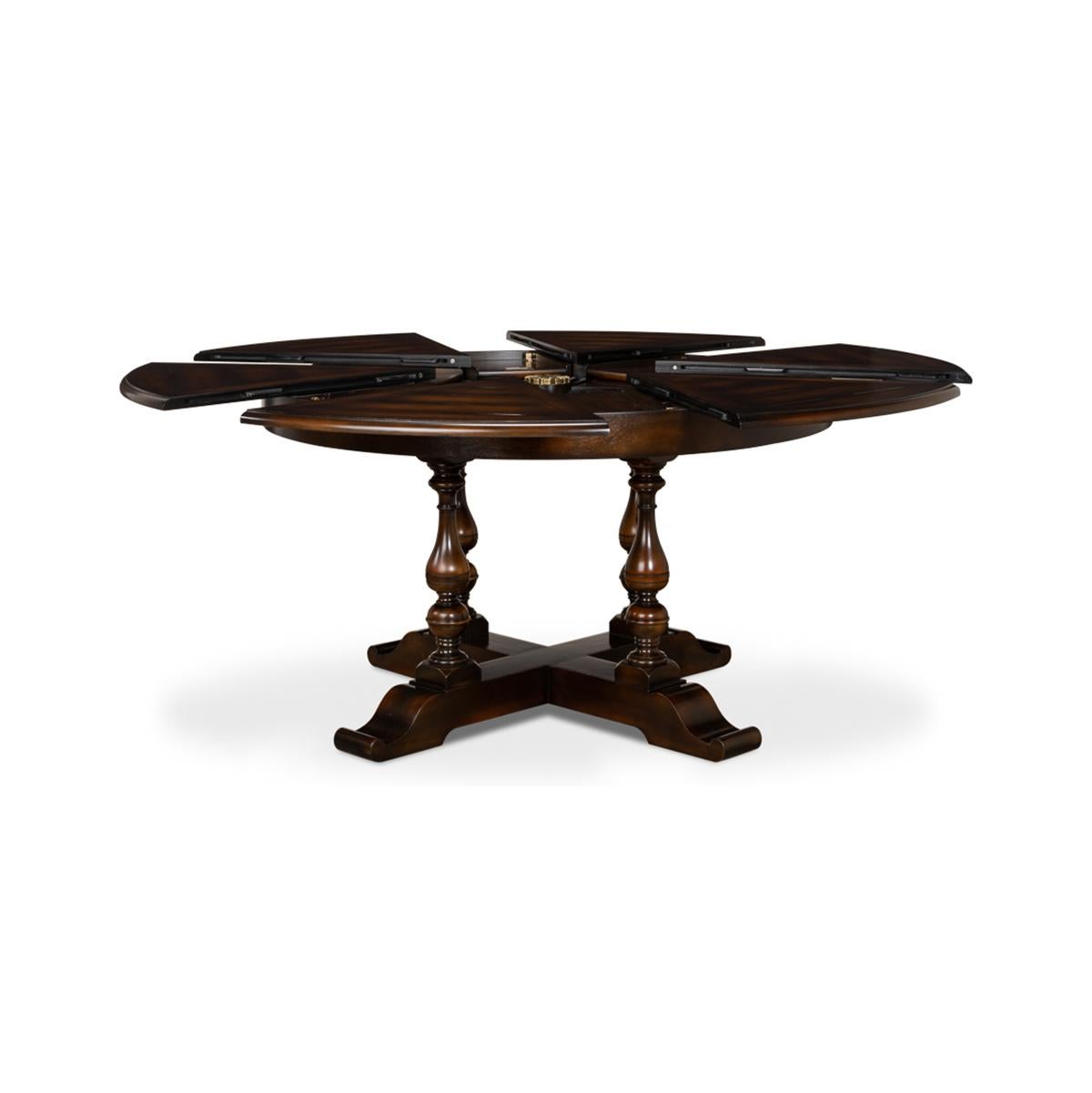 This dining table is veneered in finely figured walnut segments and supported on four baluster form turned legs leading to an 