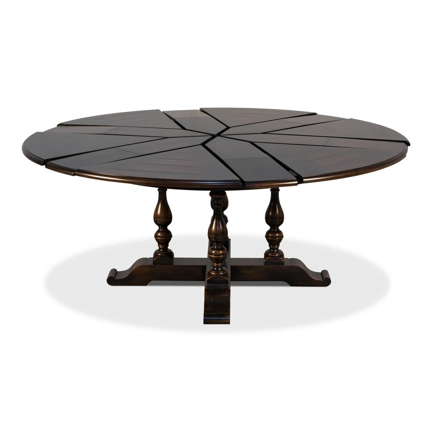 Early English style round extension dining table in dark ebony finish. This dining table is veneered in finely figured walnut segments and supported on four baluster form turned legs leading to an 