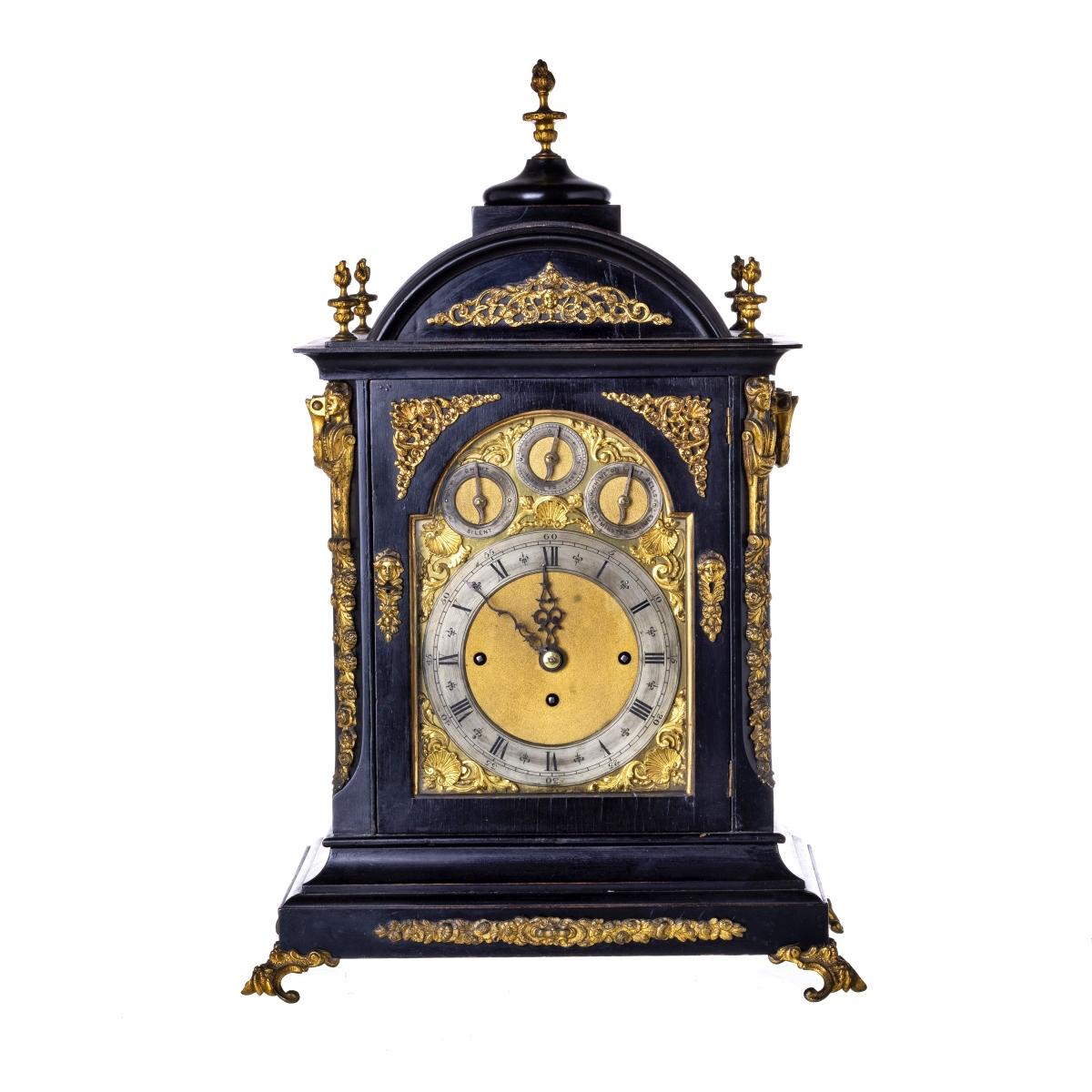 ENGLISH TABLE CLOCK
19th Century
George III style. 
Ebonized wood box, with embossed, pierced and gilt brass friezes and applications 