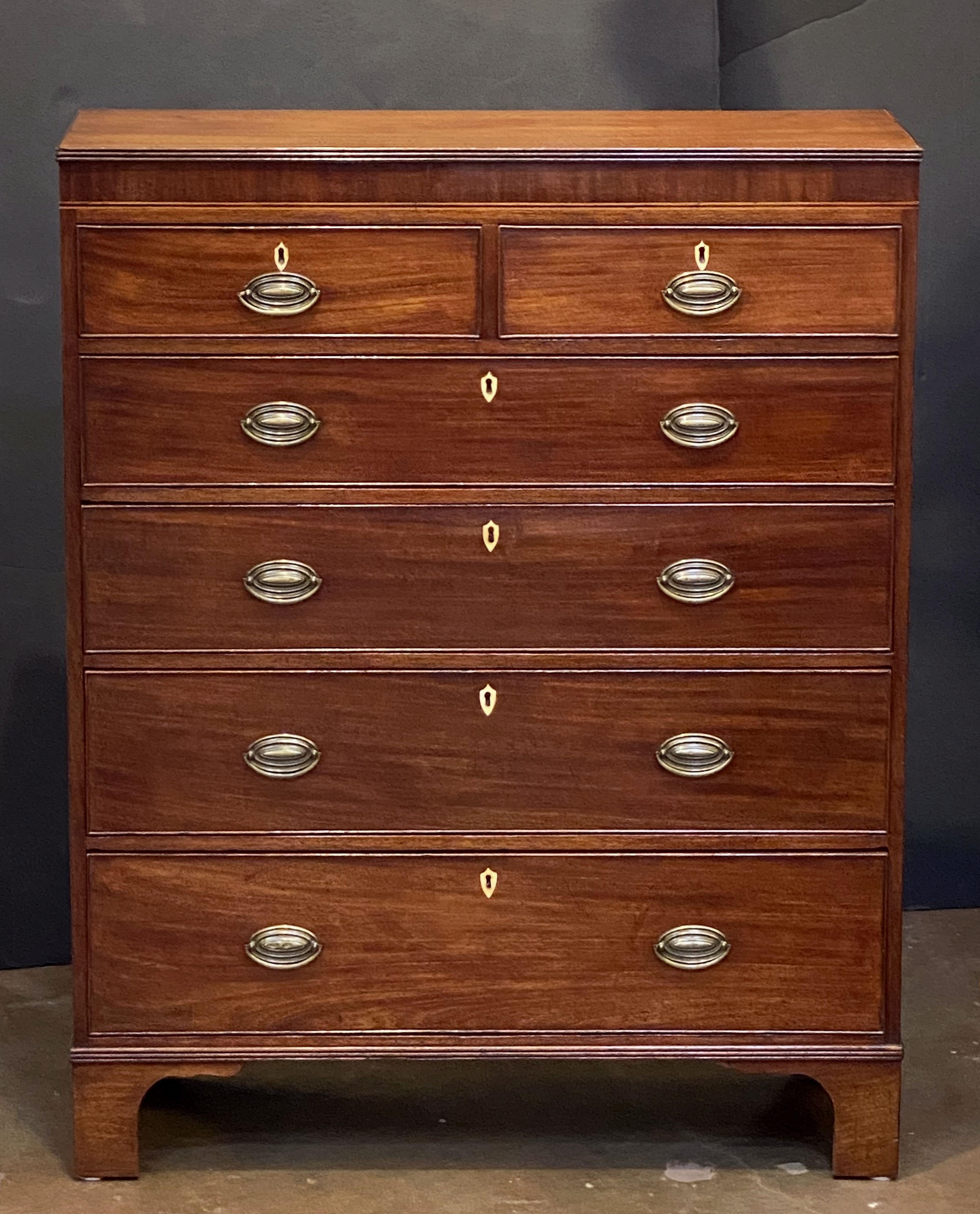 A fine English tall chest or high chest of mahogany, featuring a moulded rectangular top with reed edge, over an inlaid frieze of two beaded short drawers over four beaded long drawers, each drawer with brass hardware and bone escutcheons. Resting